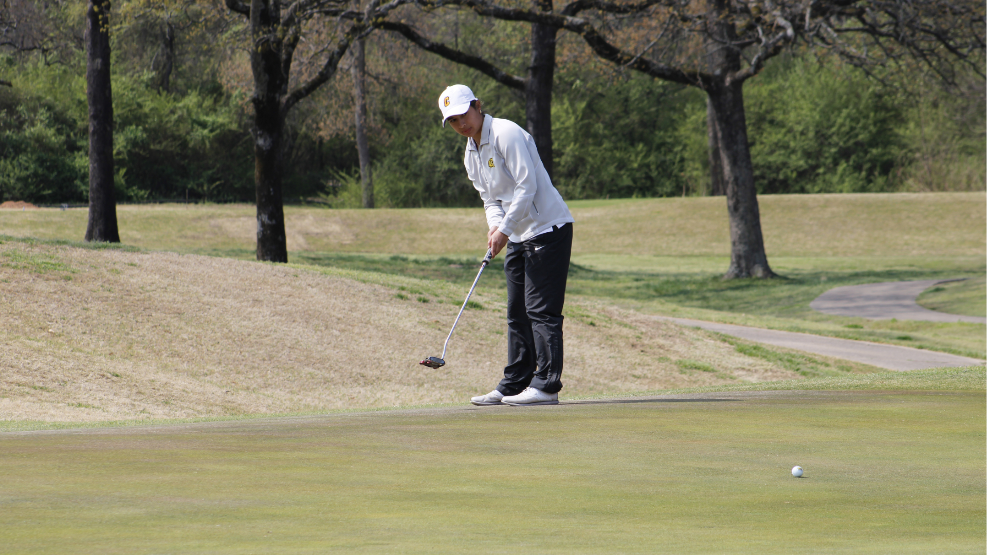 Cameron women's golfer hitting a putt