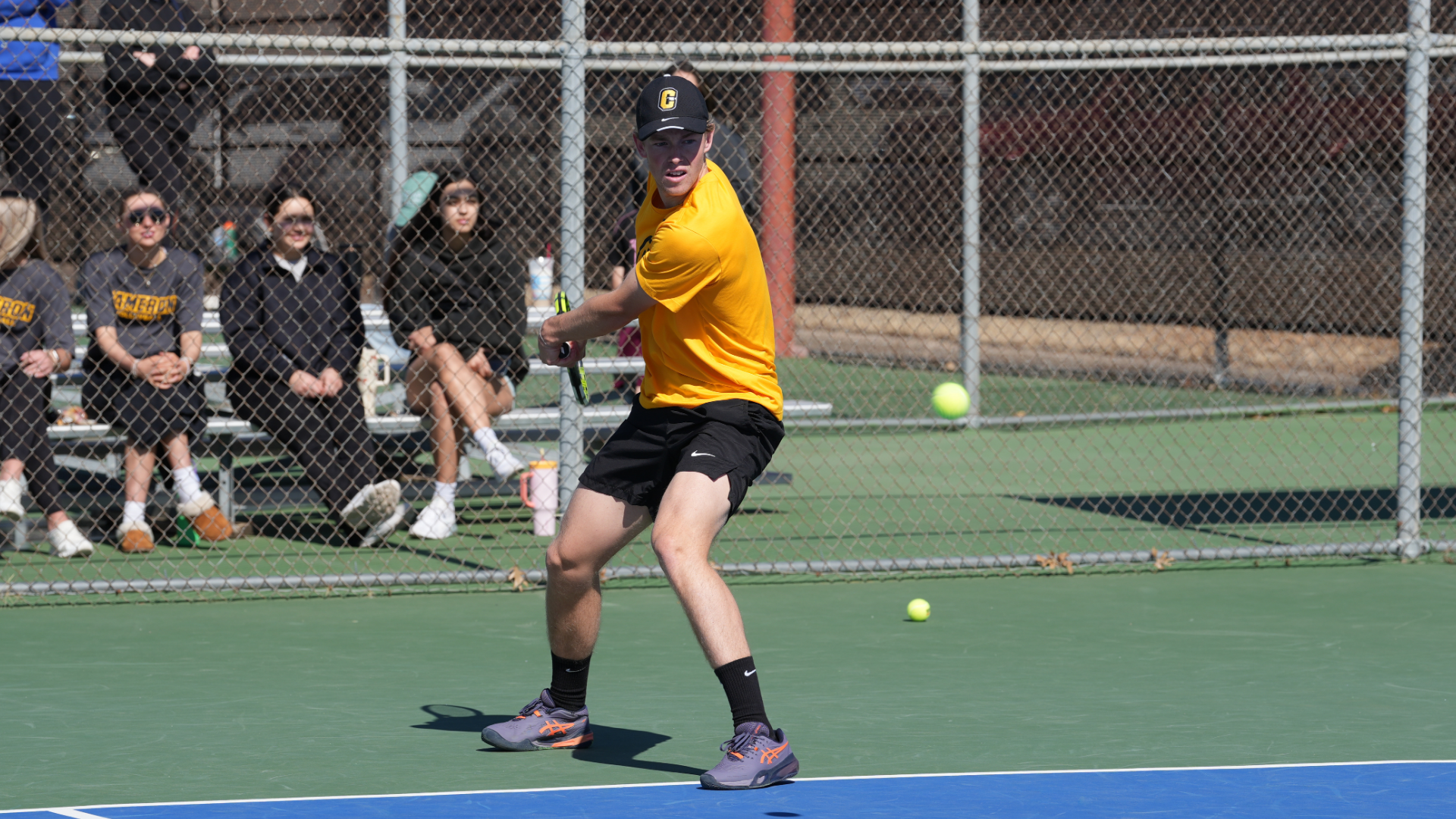 Cameron men's tennis player hitting a backhand