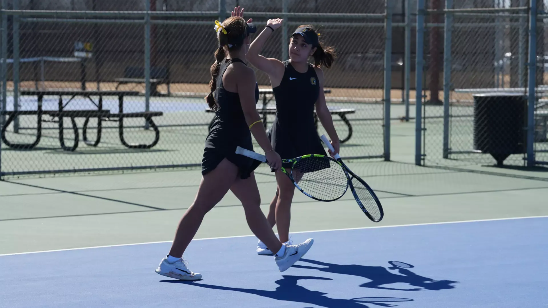 Cameron women's tennis players high-fiving