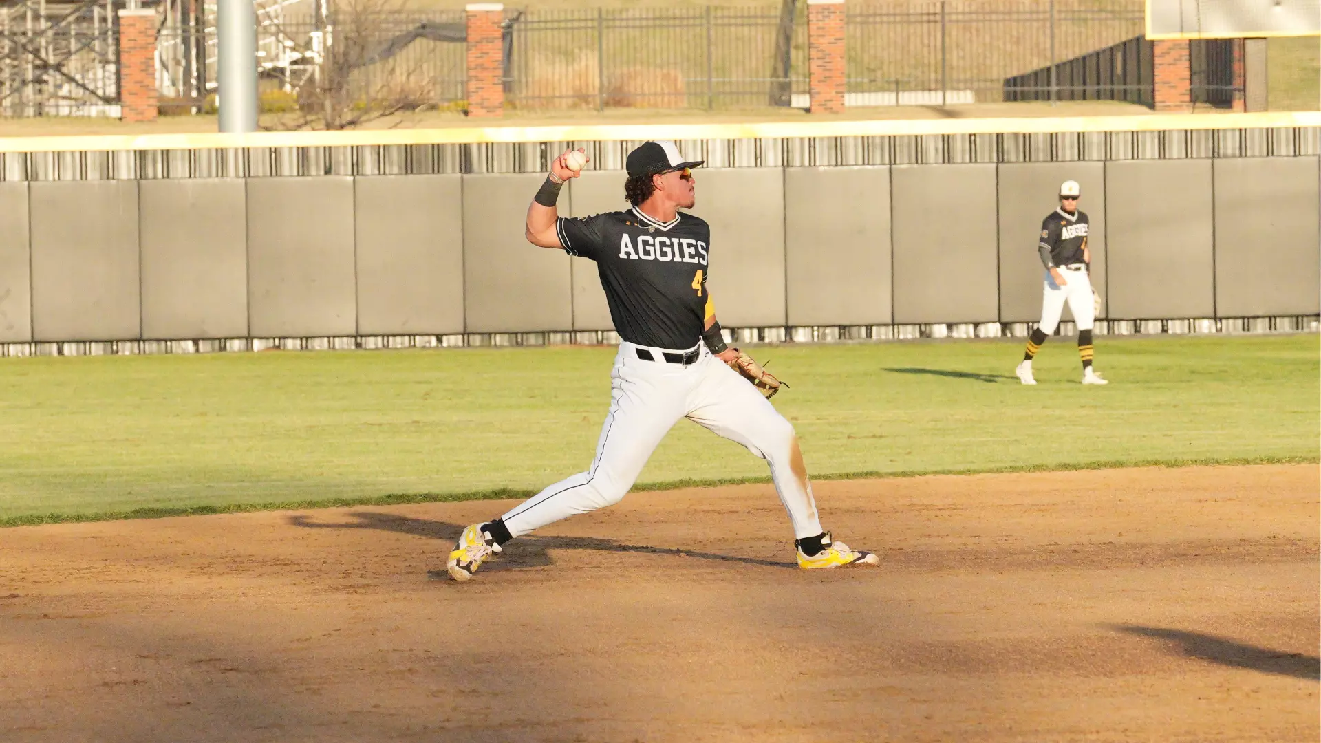 Cameron shortstop wearing a black jersey about to make a throw