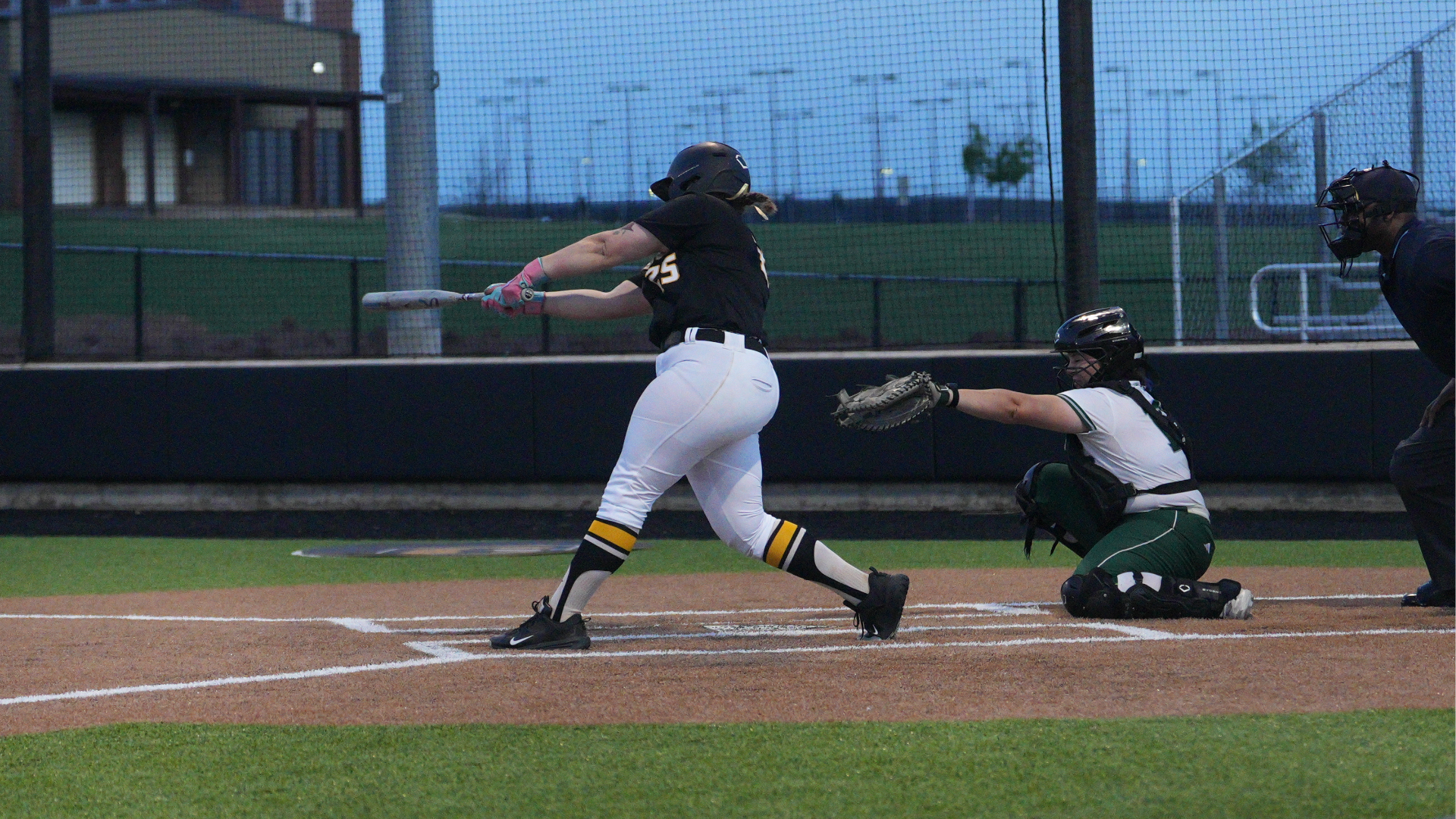 Cameron softball player #25 Haley Gardella swings the bat in front of Eastern New Mexico catcher