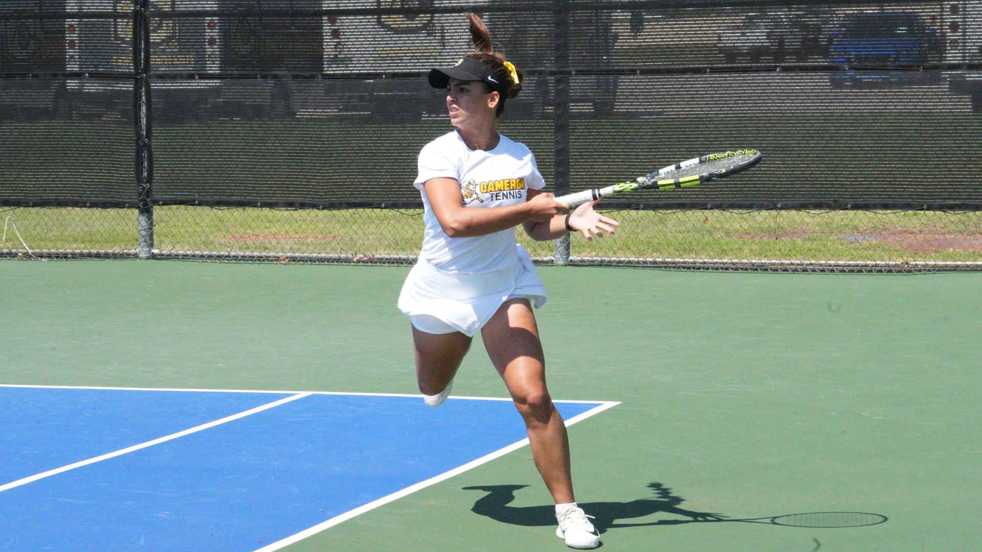 Cameron women's tennis player following through after hitting a forehand