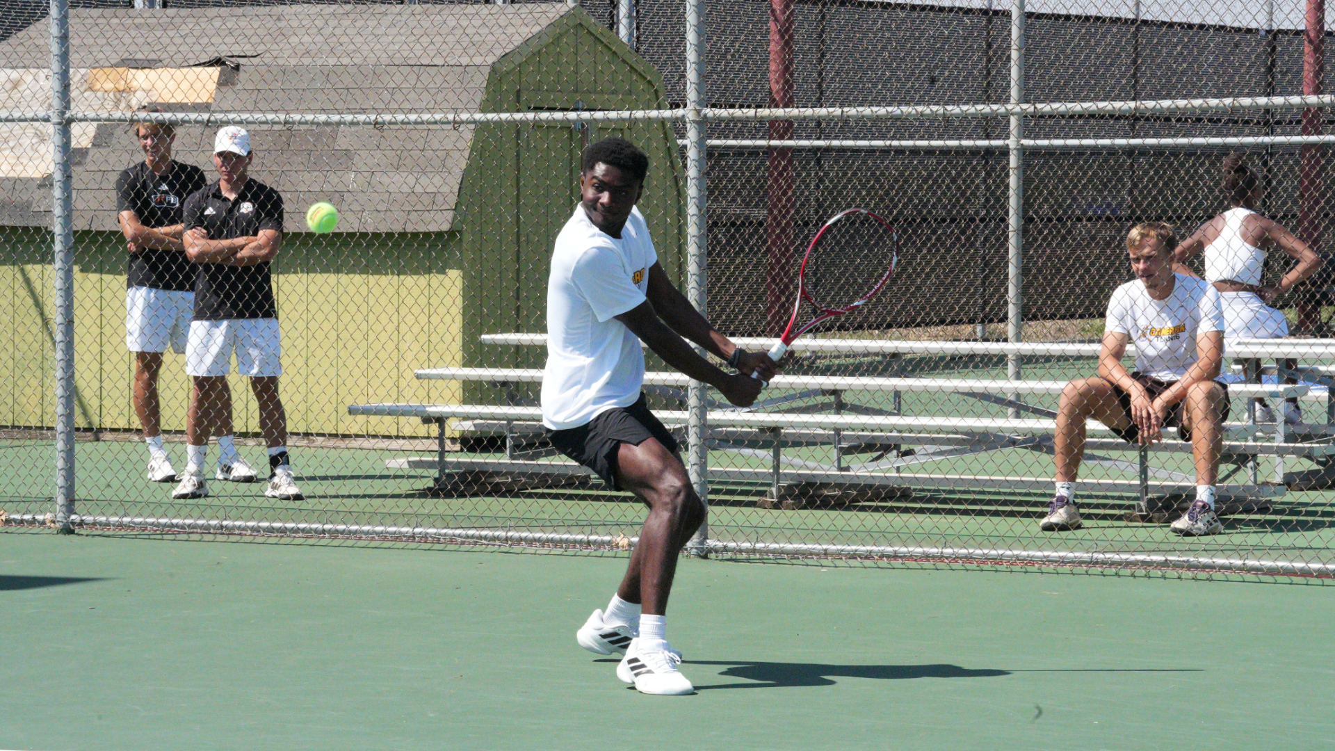 Cameron men's tennis player about to hit a backhand, with the ball right in front of him