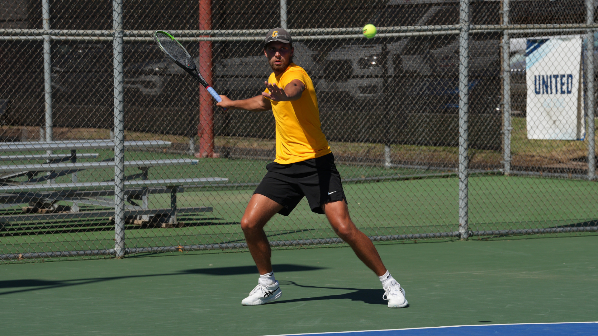 Cameron men's tennis player preparing to hit a forehand
