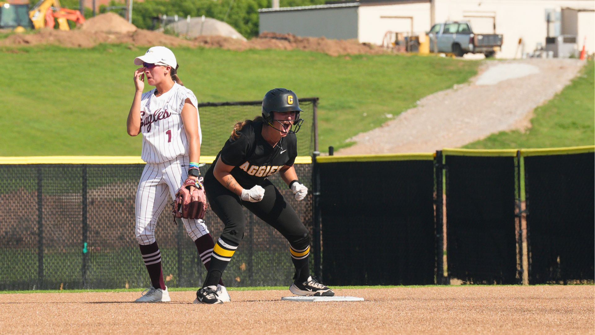 Softball player Rylee Ross celebrates a double with Oklahoma Christian player nearby. 
