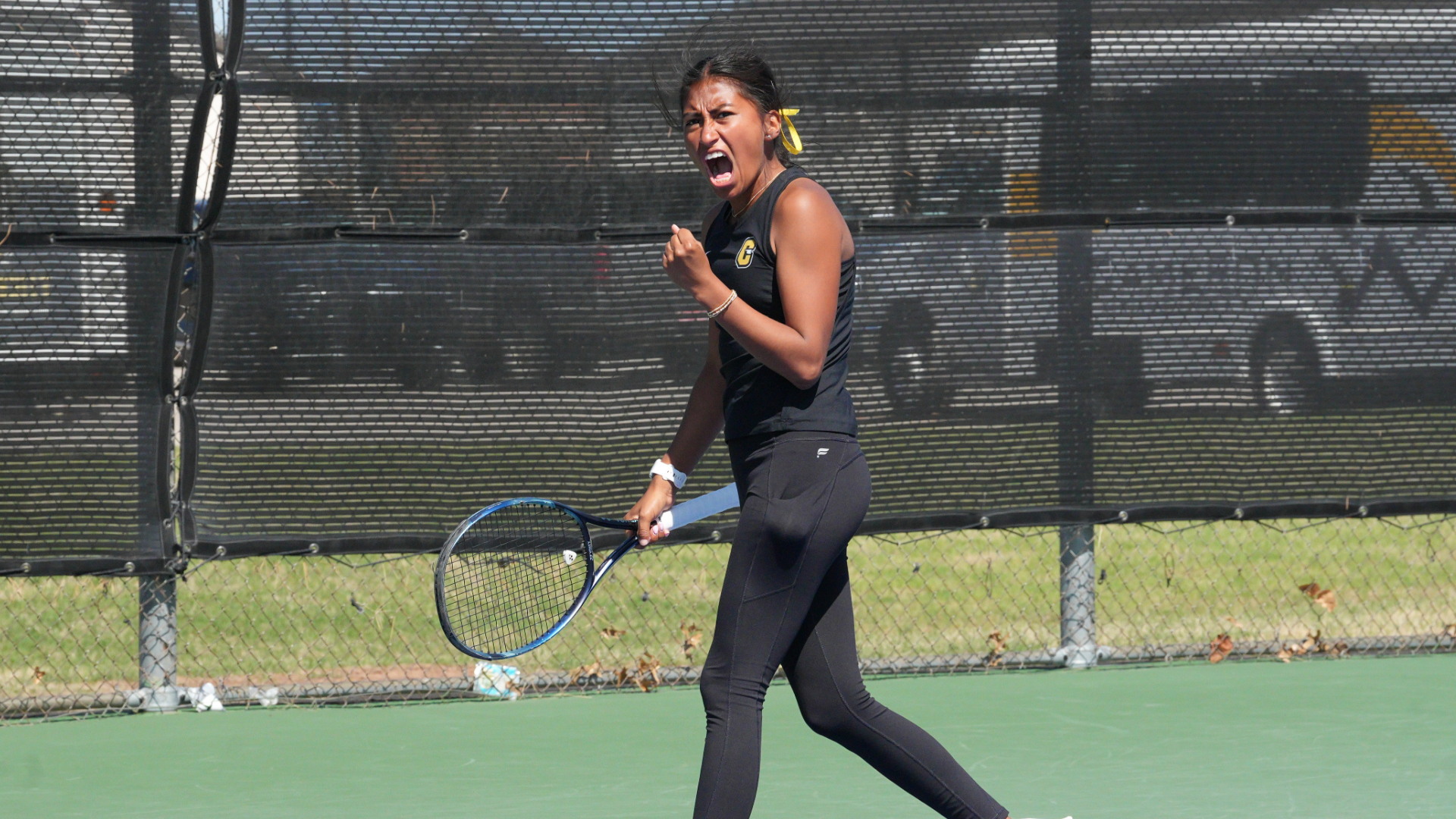 Cameron women's tennis player Alexa Garcia fist pumps and yells in celebration