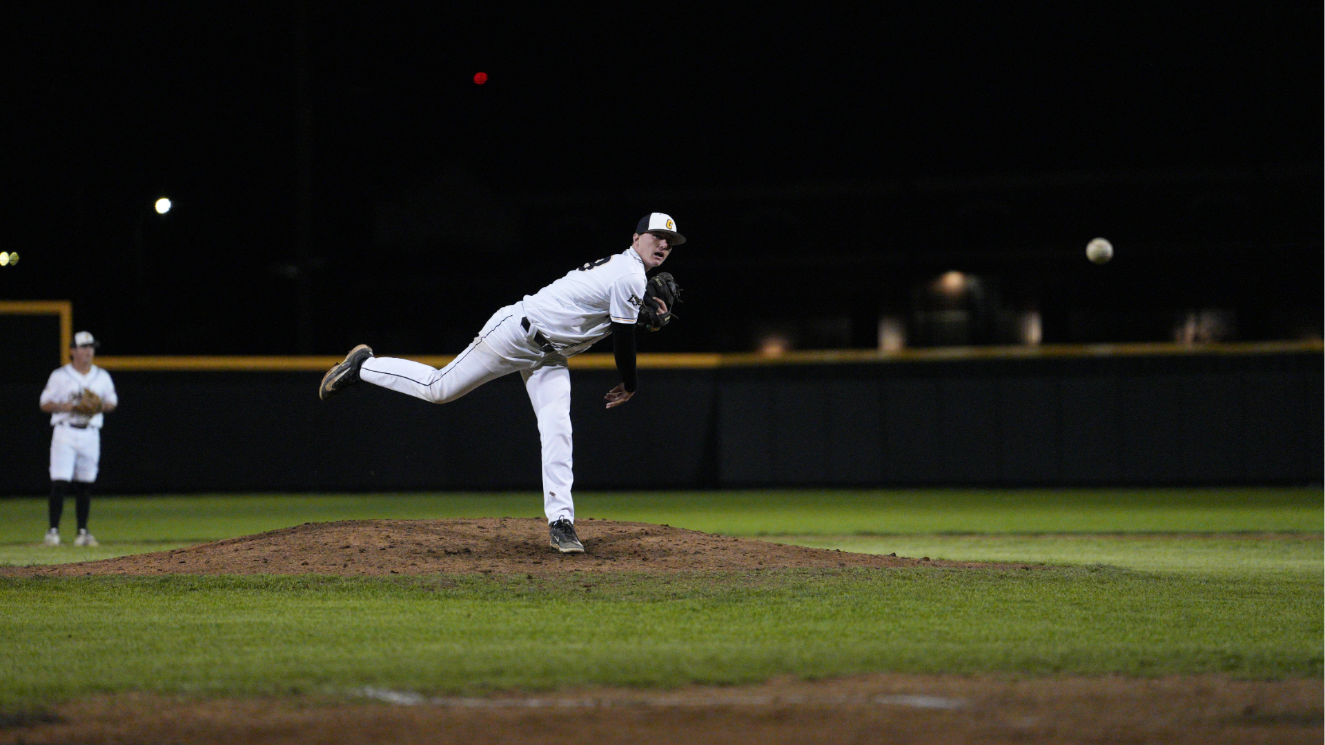 Cameron baseball pitcher throwing a pitch in a night game