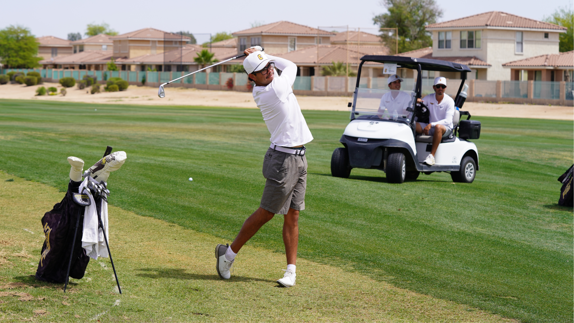 Cameron men's golfer in the follow through of his swing