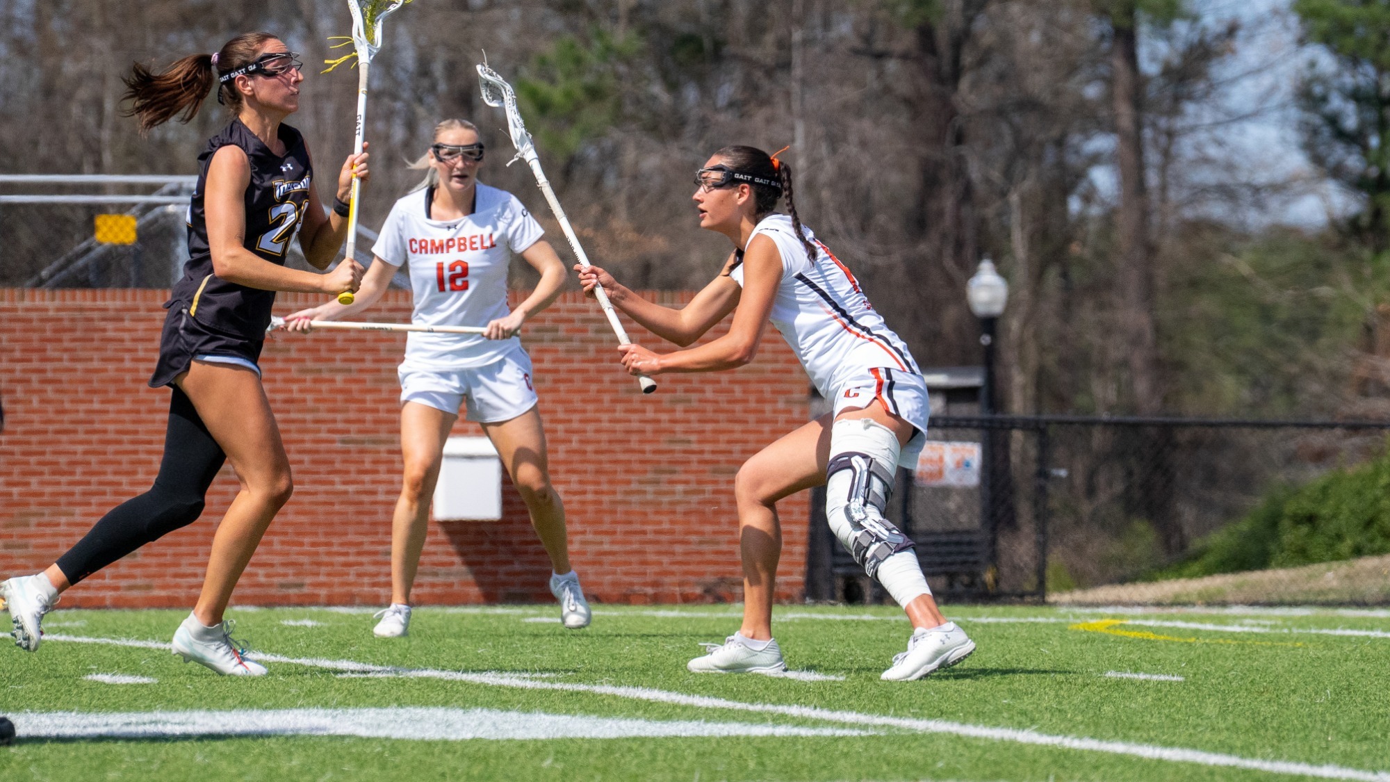 Emily Wilson defending a Towson player with #12 Hailey Kohlmann in the background