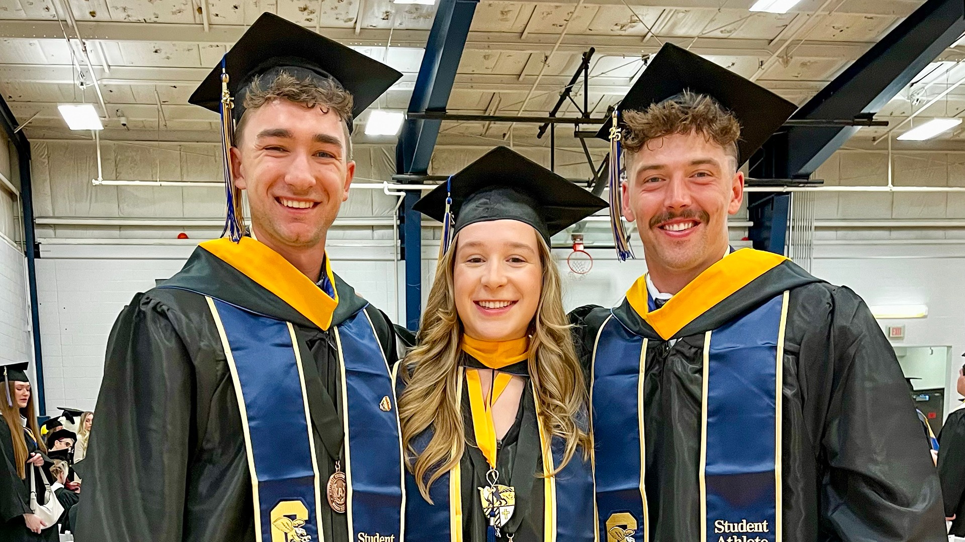 Canisius student athletes Peyton Consigli (left), Jillian Hanna and Tyler Greenleaf pose for a group photo after graduation ceremonies at the Koessler Athletic Center