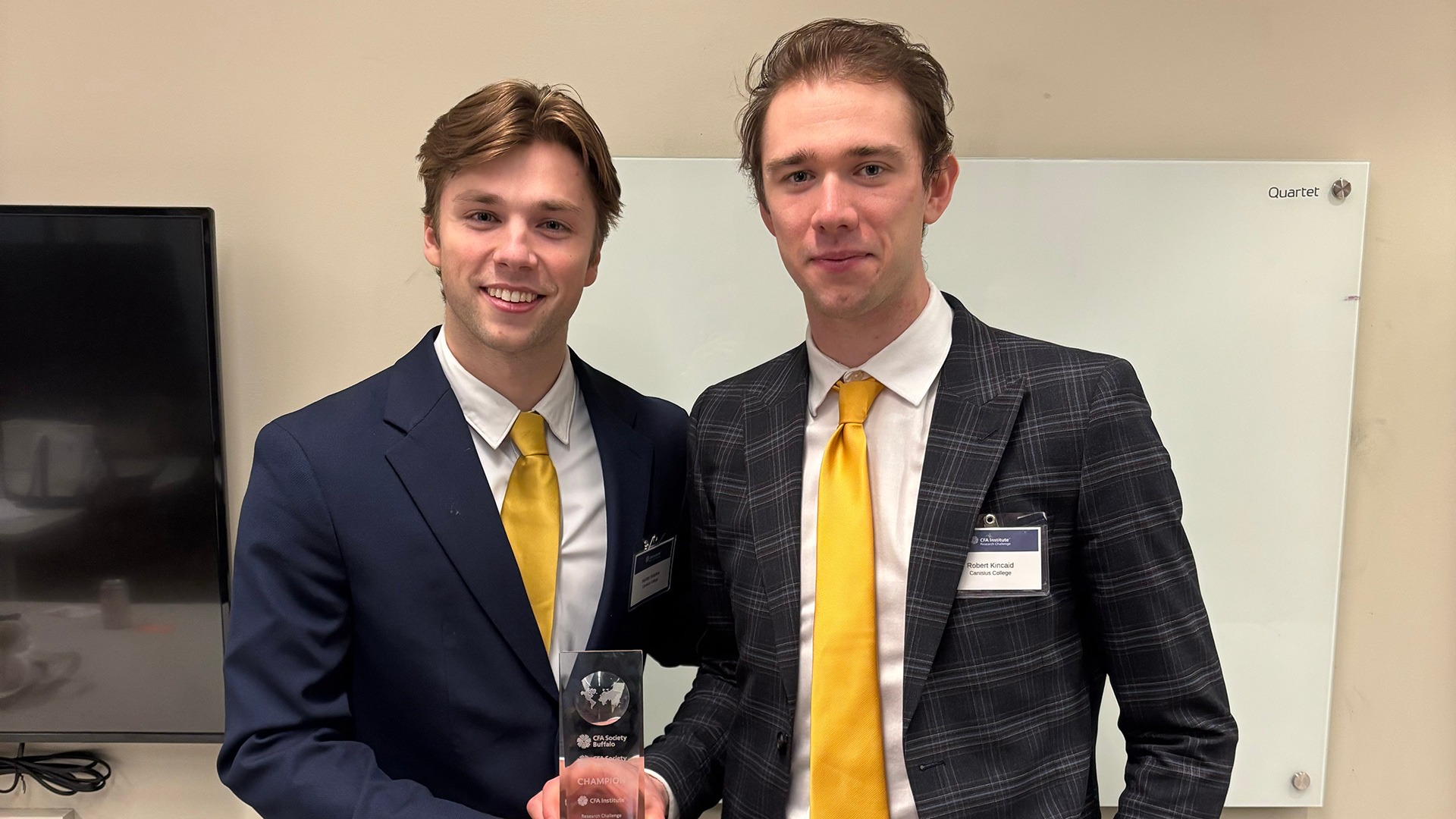 Canisius hockey student-athletes Hunter Andrew (left) and Robert Kincaid pose with their trophy after helping the GGF claim first place in the Chartered Financial Analyst (CFA) Institute Research Challenge of Western New York on Feb. 7
