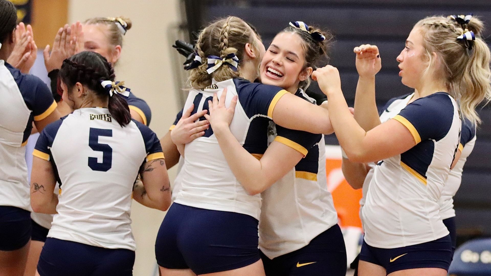 Eva Goode hugs a teammate after an event in an acrobatics and tumbling meet at the Koessler Athletic Center