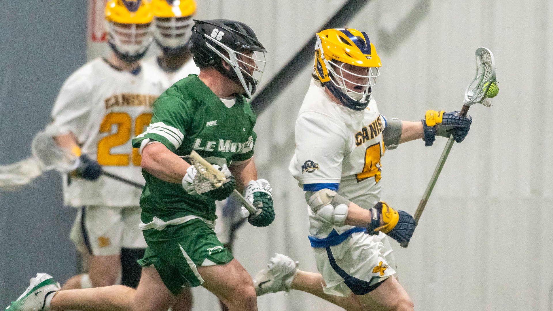 Canisius face-off specialist Micah Hanson runs with the ball while Le Moyne's Mason McCombs gives chase during game action at Sahlen's Sports Park in Elma, N.Y. 