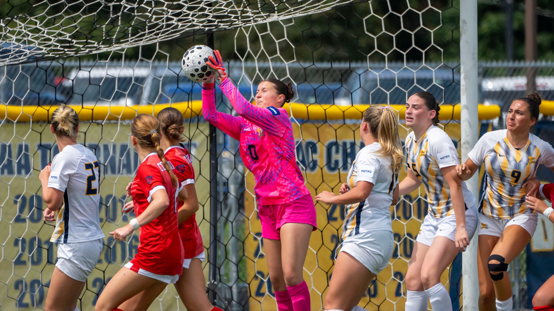 Canisius goalkeeper Alexa Turmel (center in pink jersey) catches the ball during game action versus Robert Morris at the Demske Sports Complex on Aug. 20, 2026