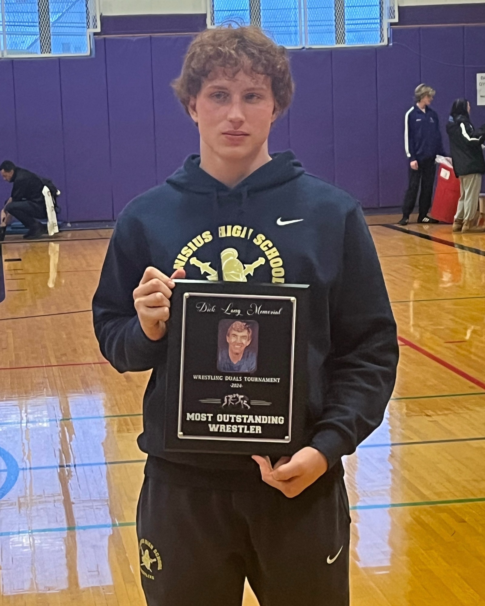 Gabe Farley stands with MOW plaque. 