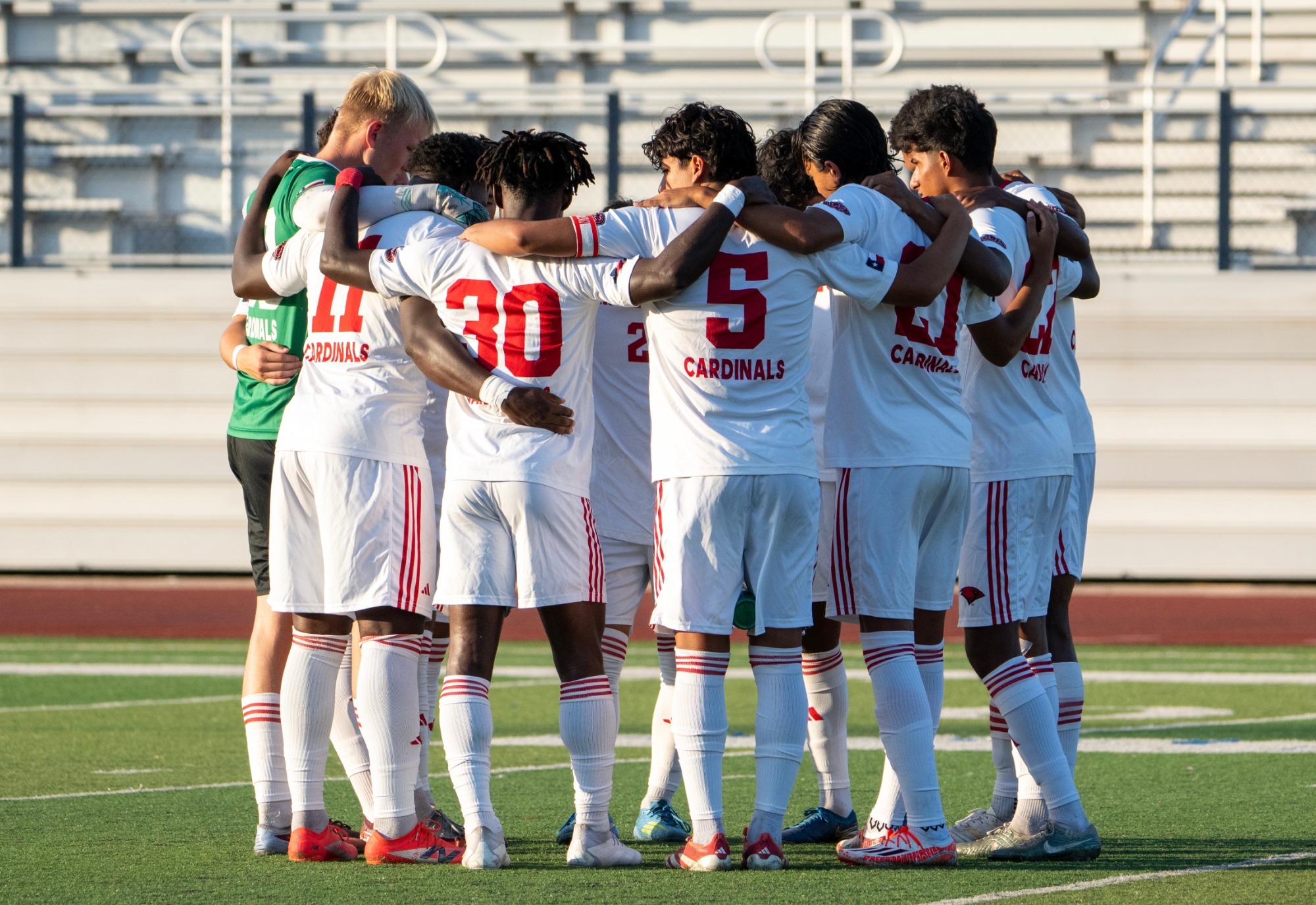 Men's Soccer huddles at match