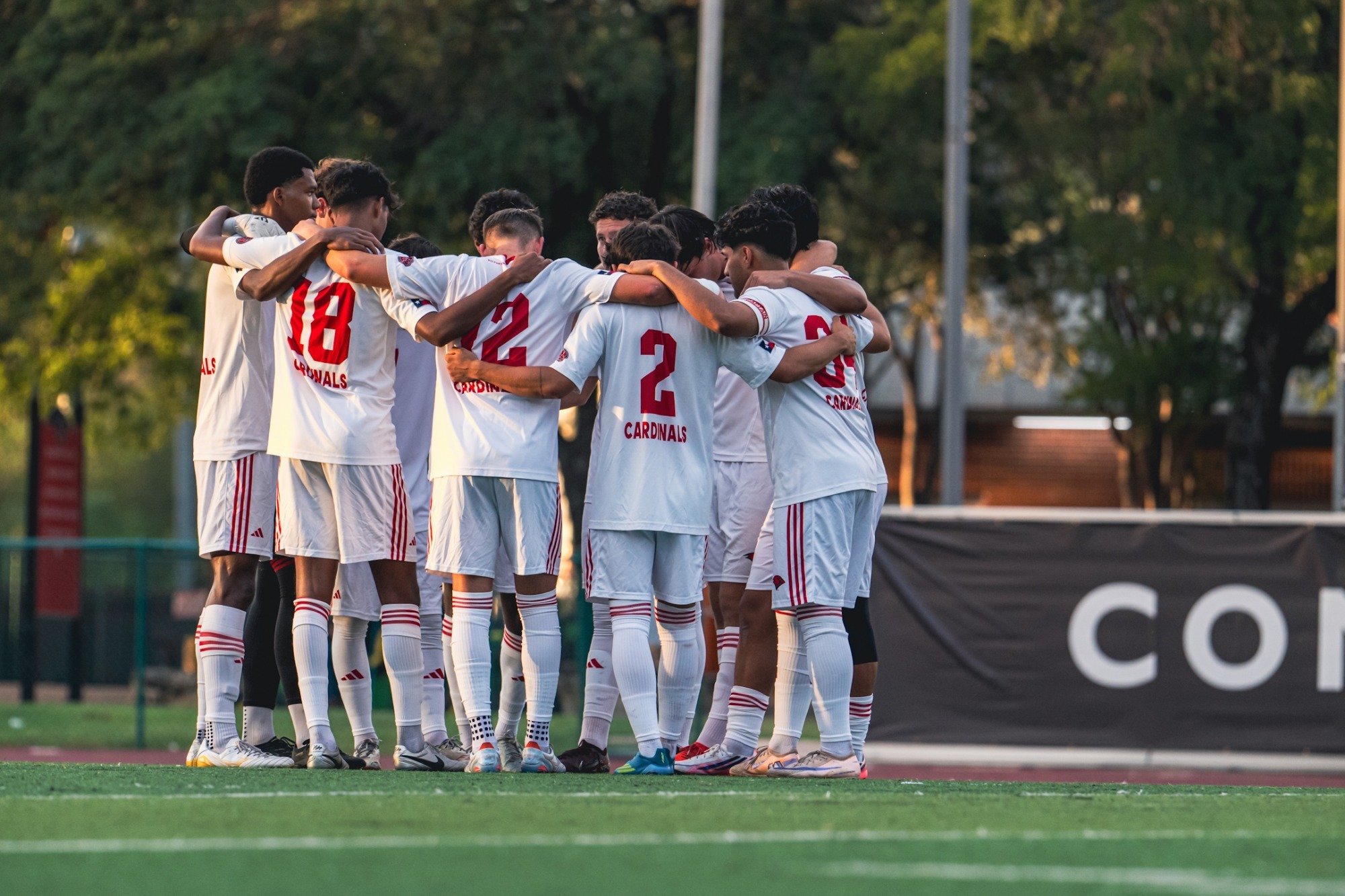 Men's soccer huddles at home
