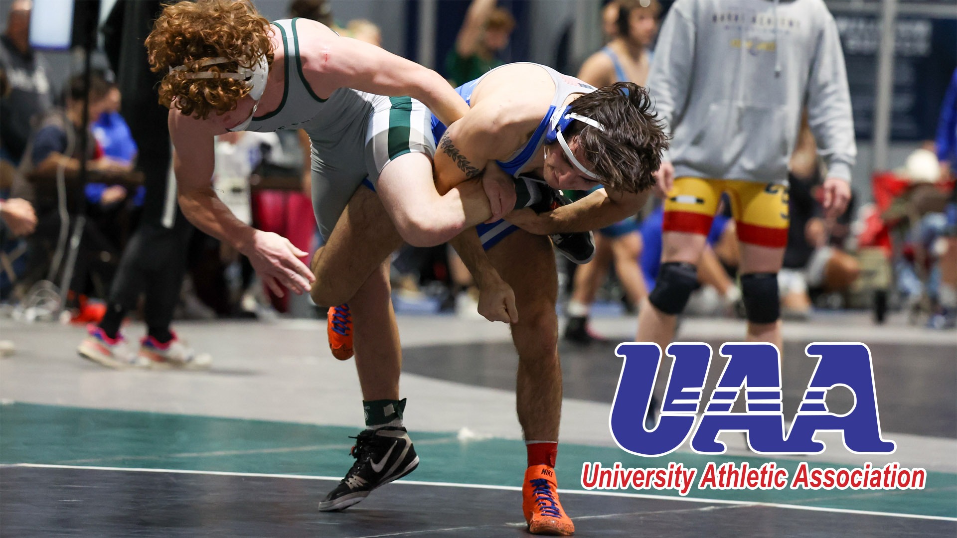 Art Martinez wrestling with the UAA logo in the bottom right corner