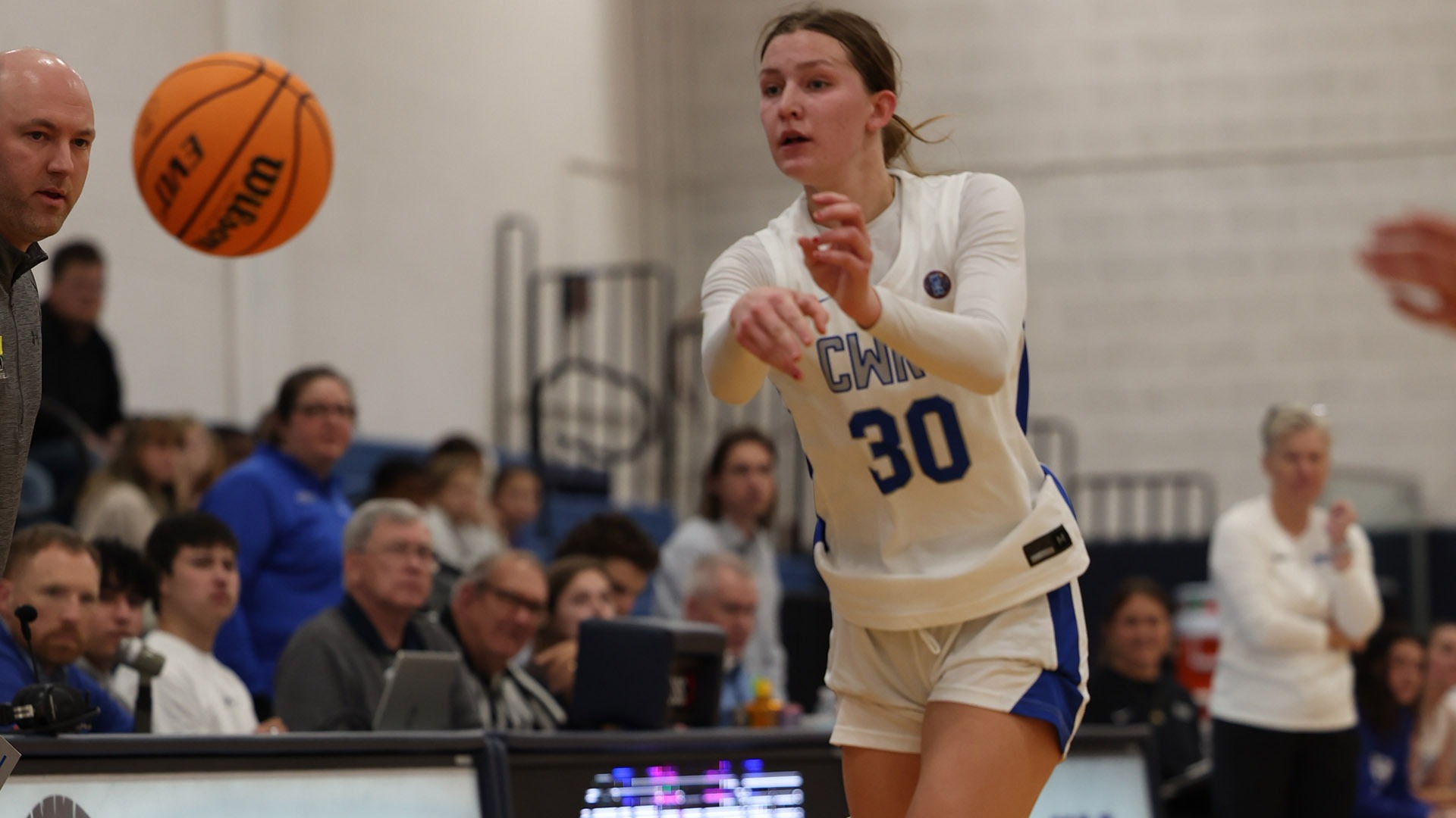 Maura Schorr passing a basketball against Adrian