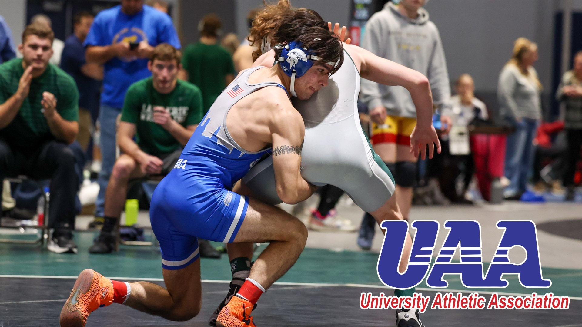 Art Martinez wrestling with the UAA logo in the bottom right corner
