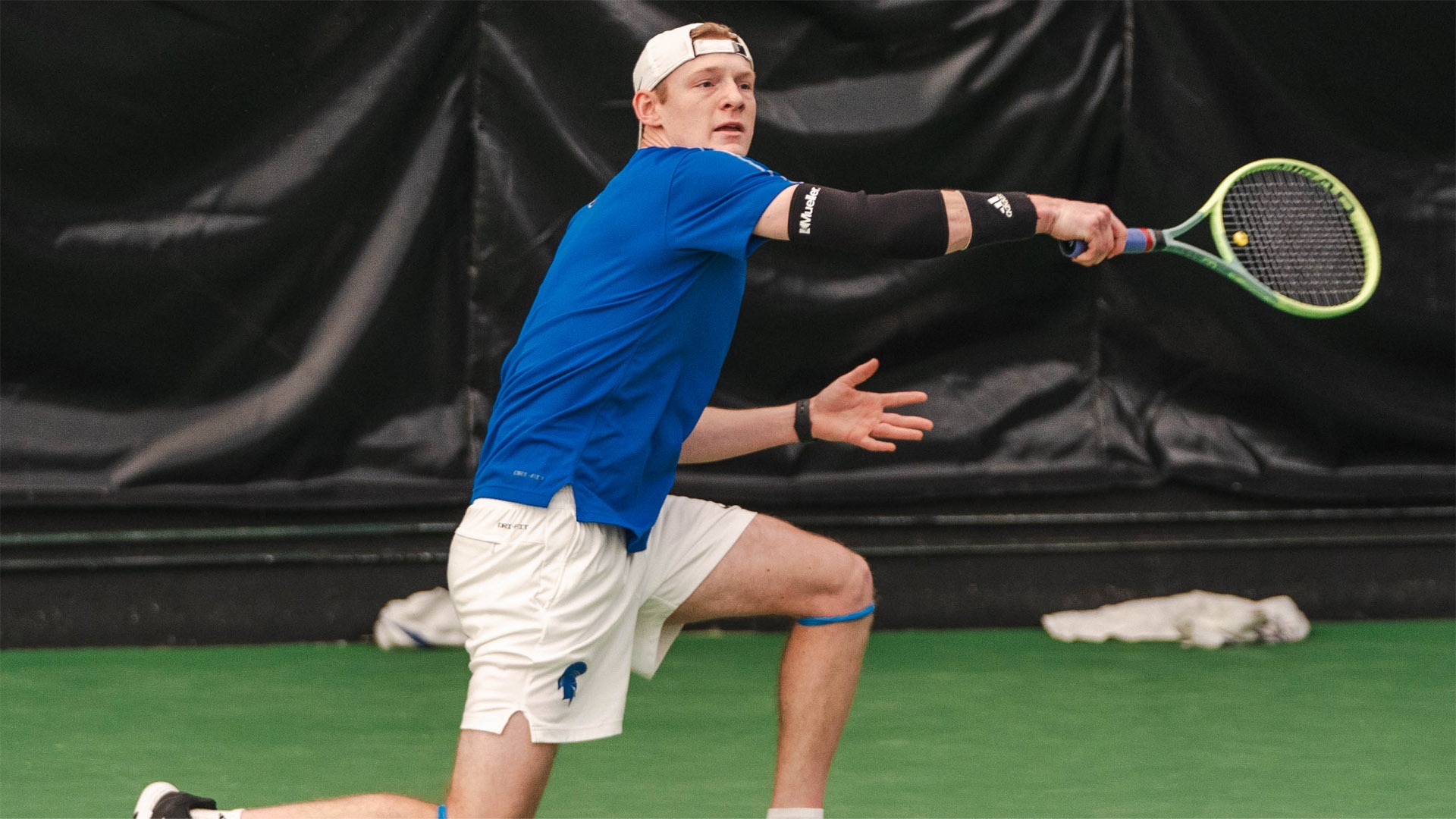 Trey Lambright in the middle of a backhanded return at the ITA Indoor Championship