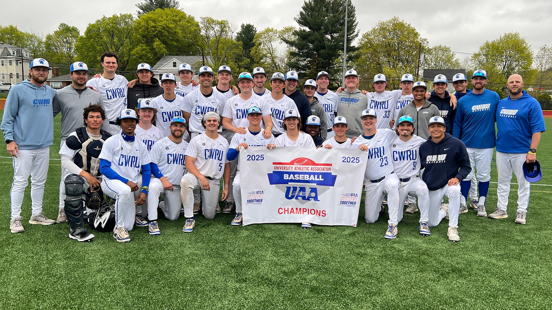 The CWRU baseball team holding the 2025 UAA Championship banner after clinching the conference title