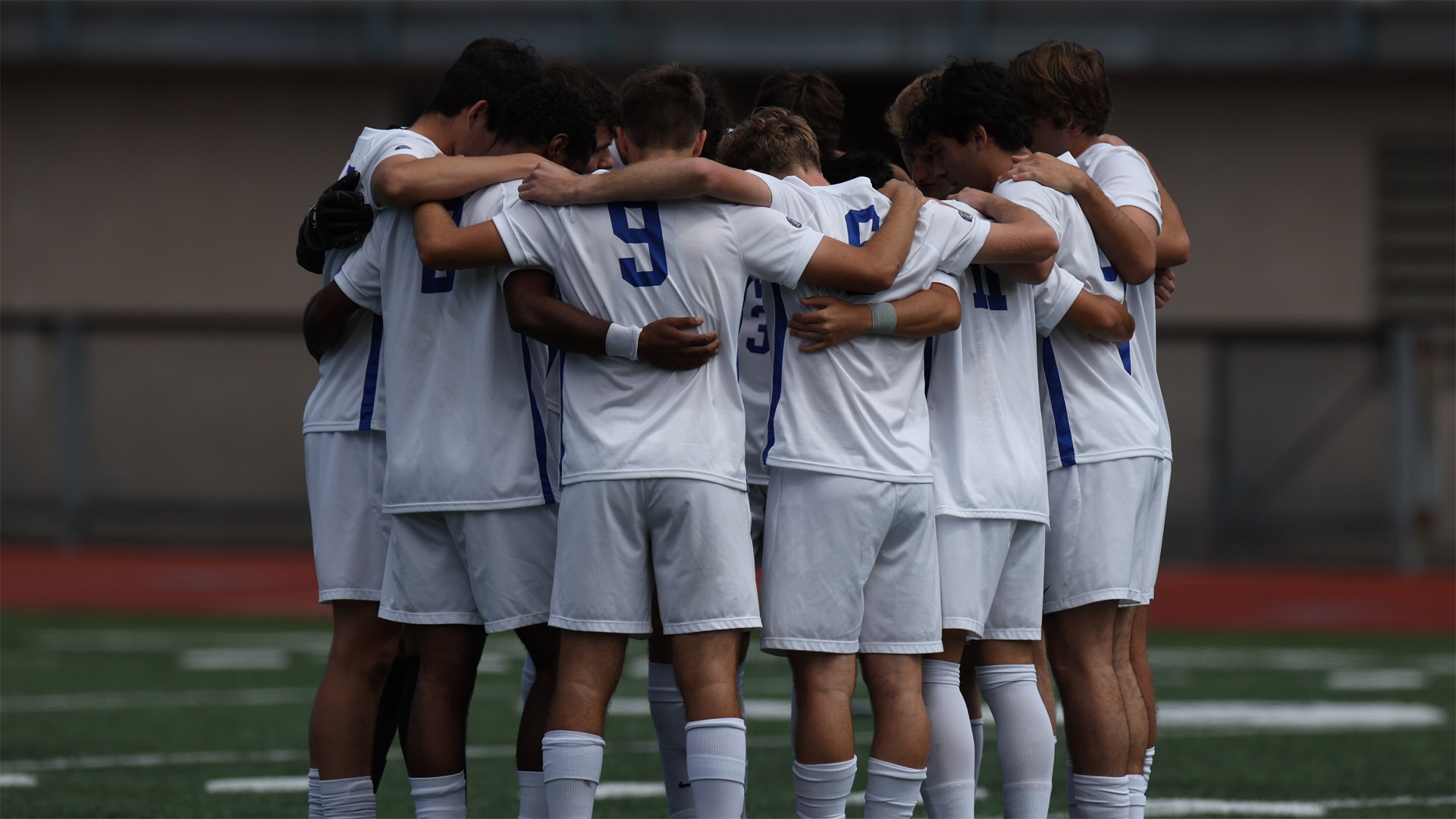 CWRU Men's Soccer team in a huddle prior to a game in 2025