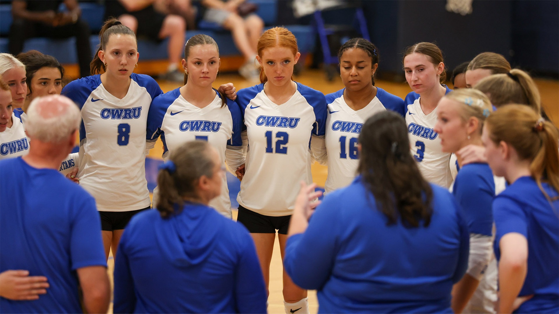 The CWRU Volleyball team in a large huddle