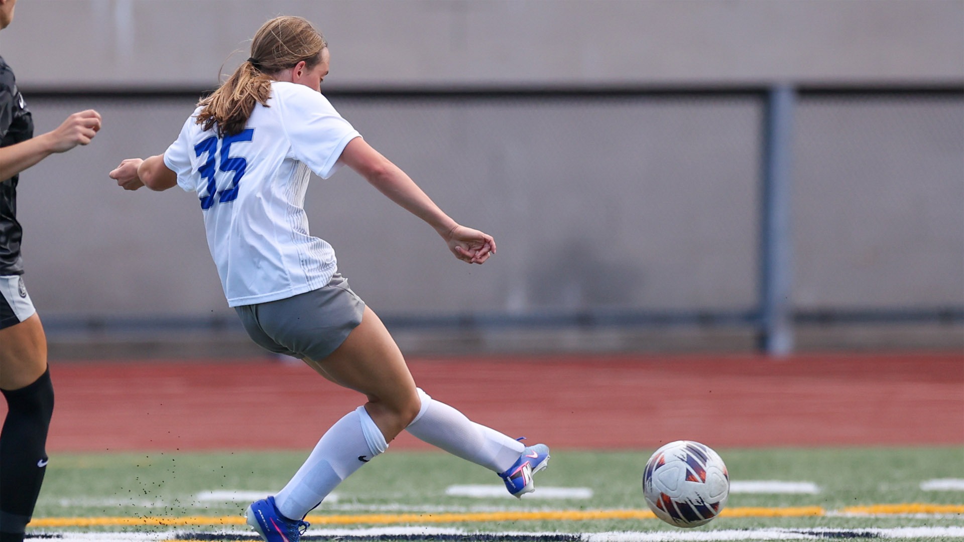 Izzy Probst kicking the ball with her left foot against Capital