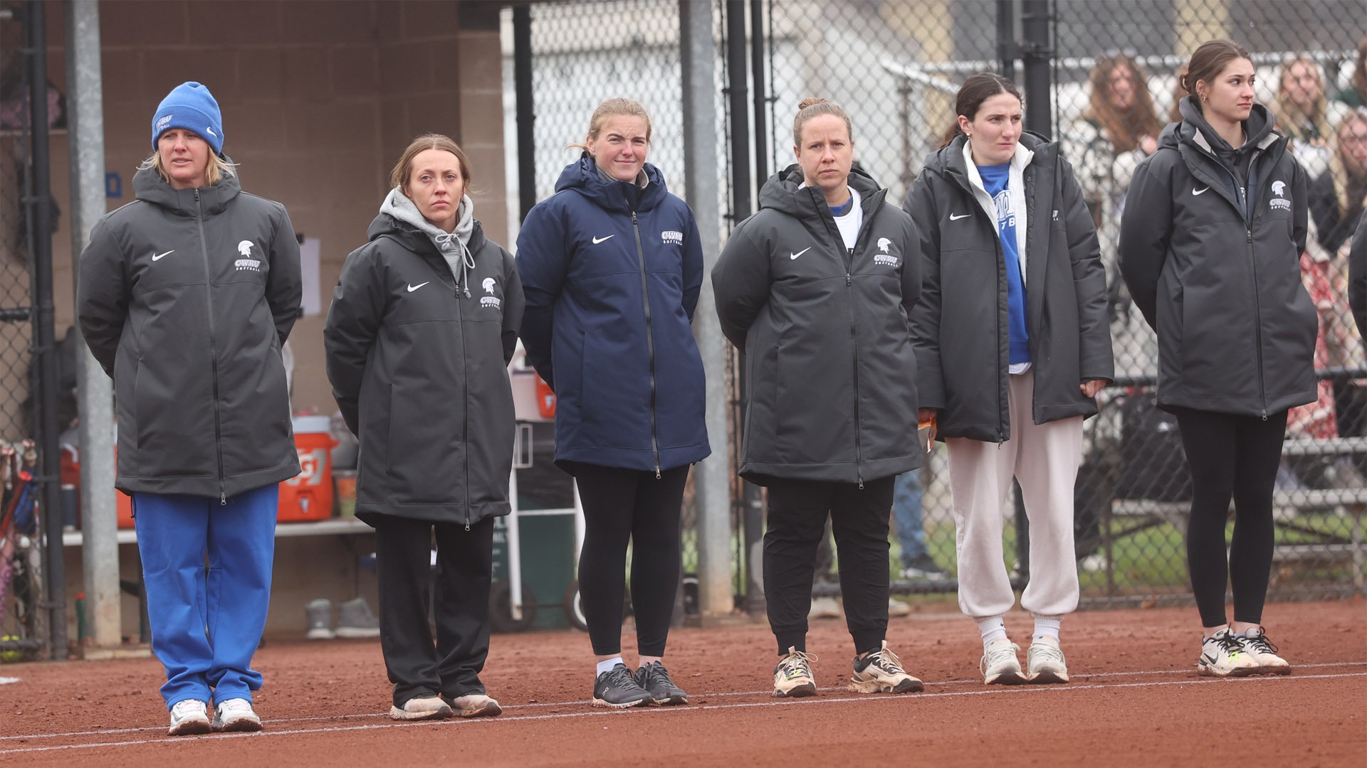 CWRU Softball coaches standing on the first base line for the national anthem