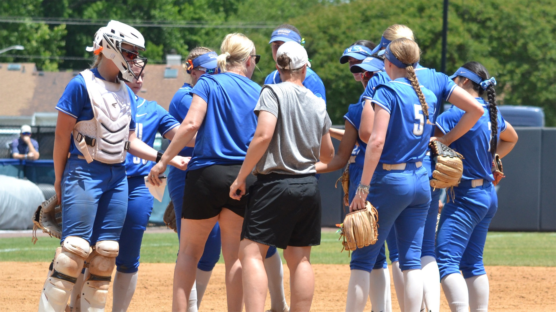 CWRU softball team in a huddle at the pitcher's circle in Virginia Beach