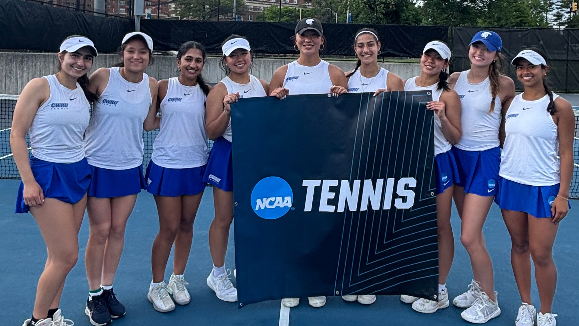 Members of the CWRU women's tennis team holding an NCAA Tennis banner at JHU