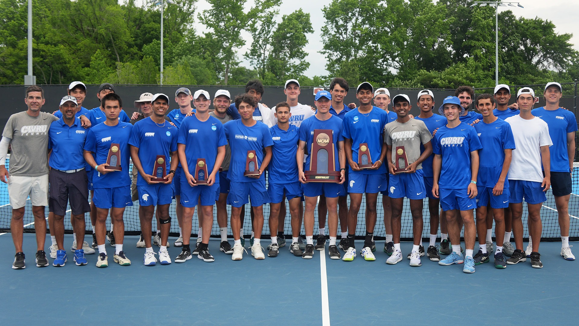 The 2026 CWRU men's tennis team posing with NCAA trophies after their semifinal match