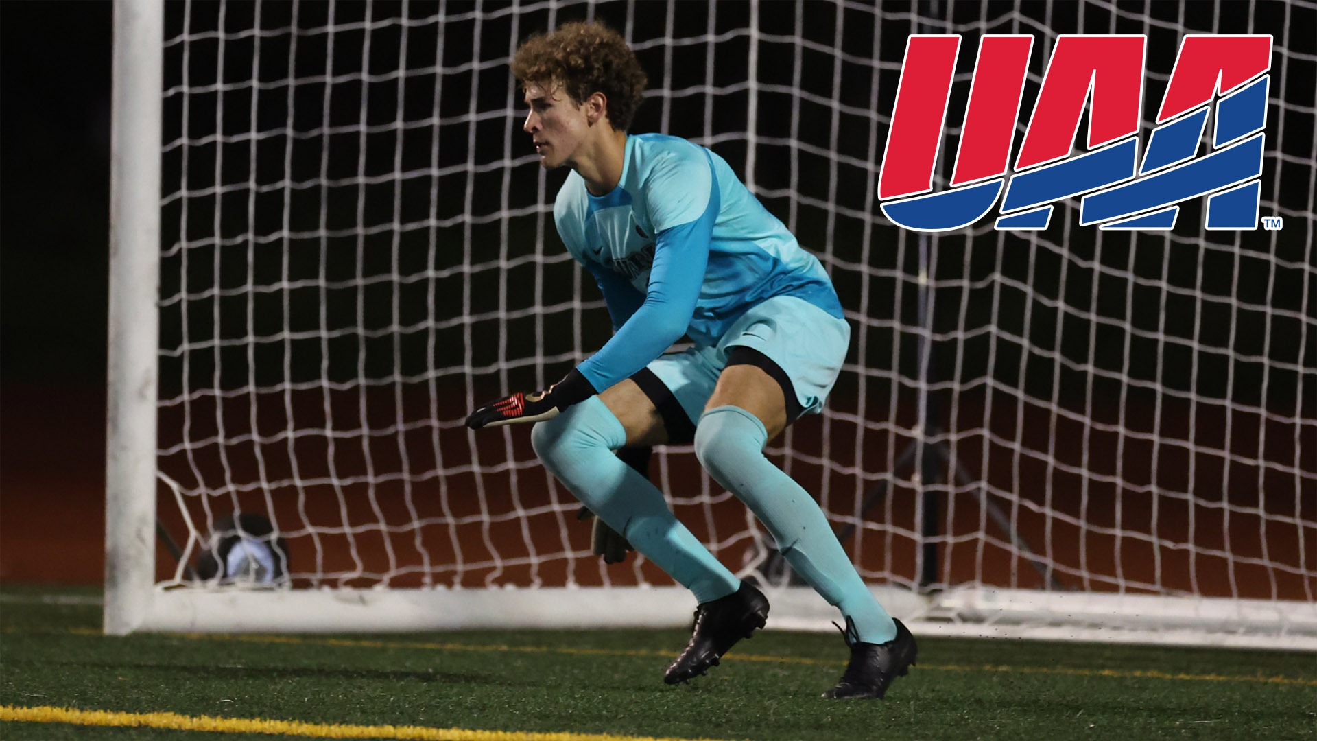 Carter Shedd about to dive for a shot with UAA logo top right