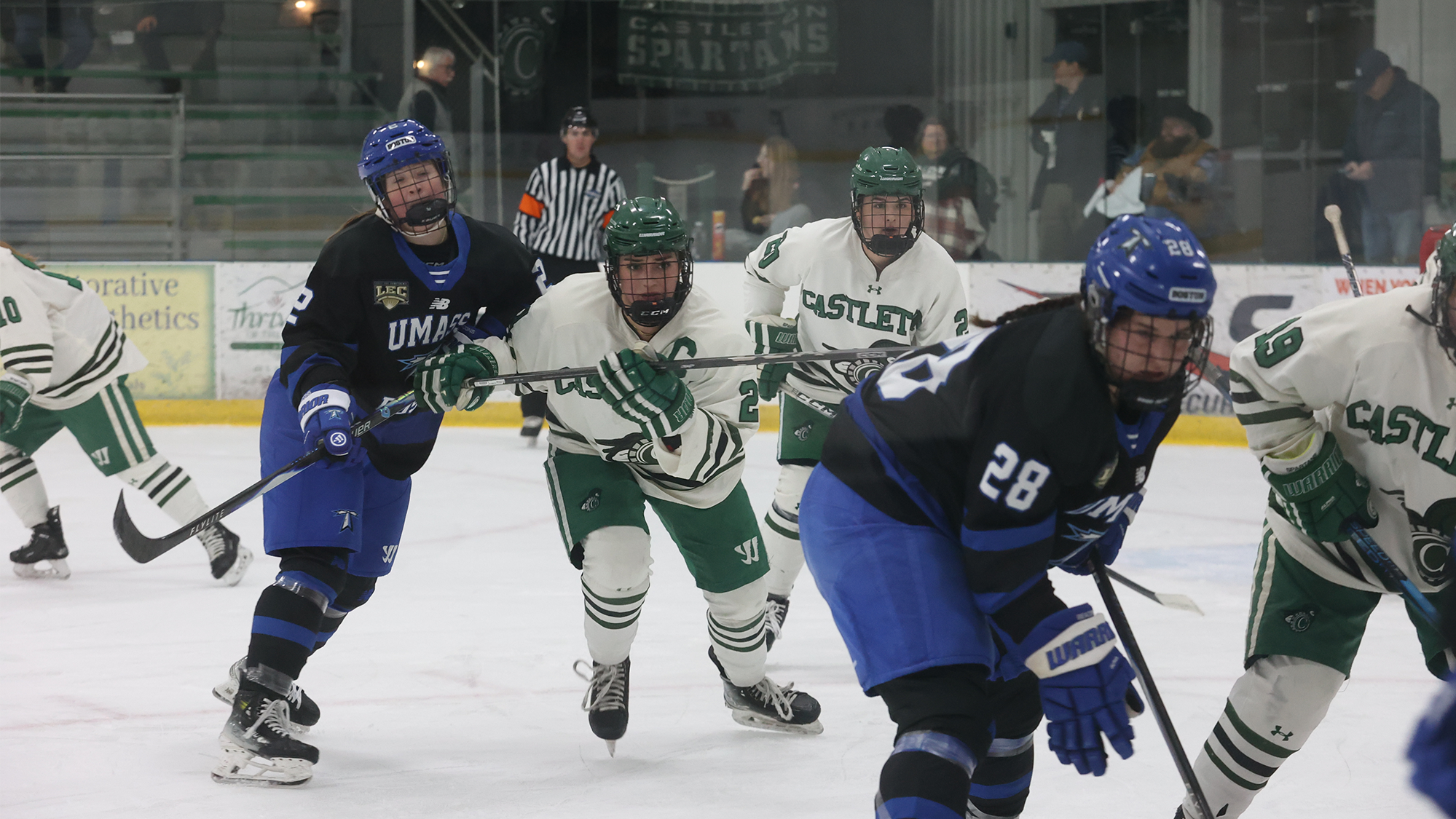 Ellie Schliebener battles with UMass Boston skaters off of a faceoff