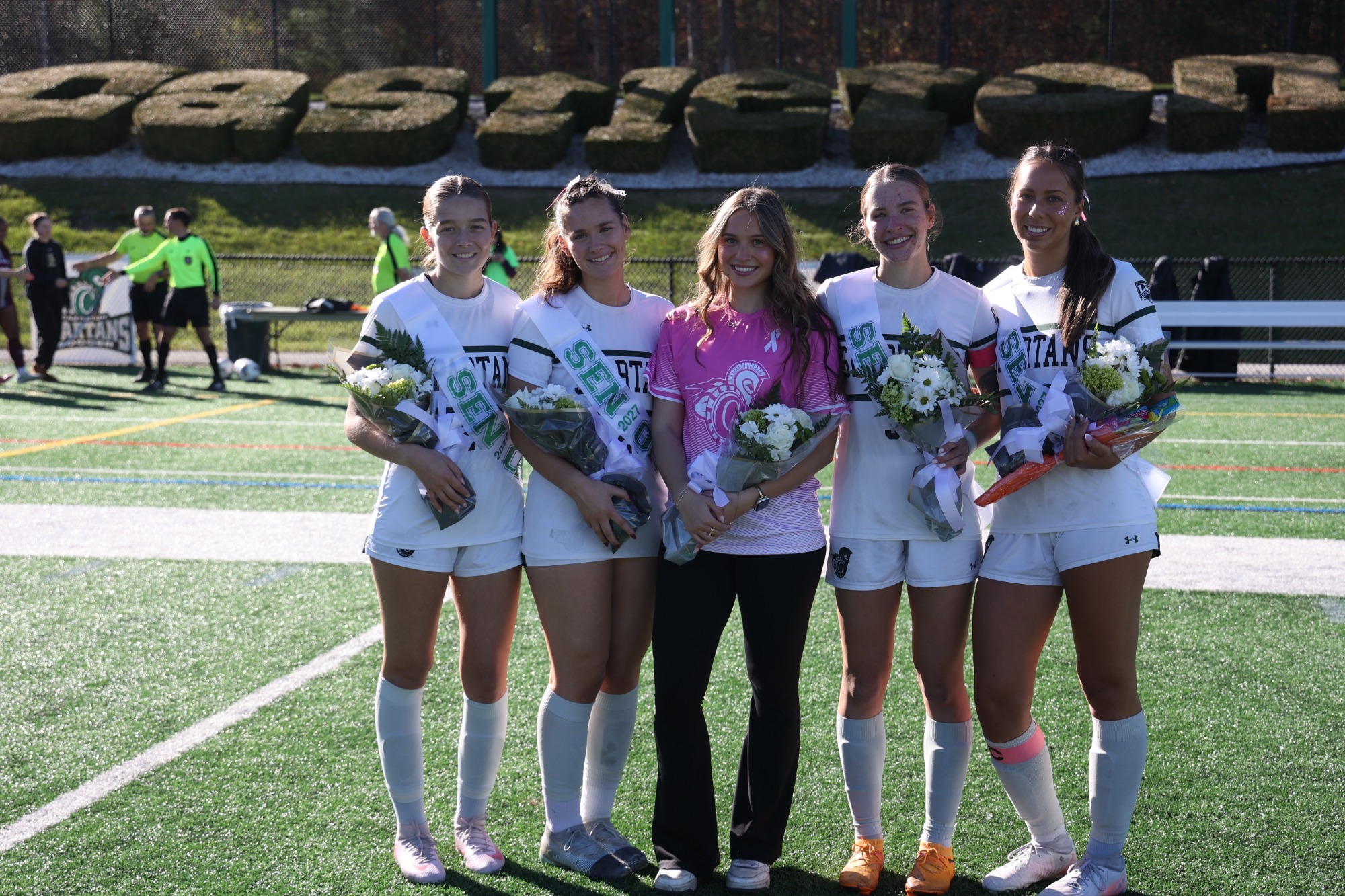 Seniors Emma Kirby, Allison Galante, Manager Renae, Kristina O'Neil, and Gwen Bridges taking a senior day picture with flowers