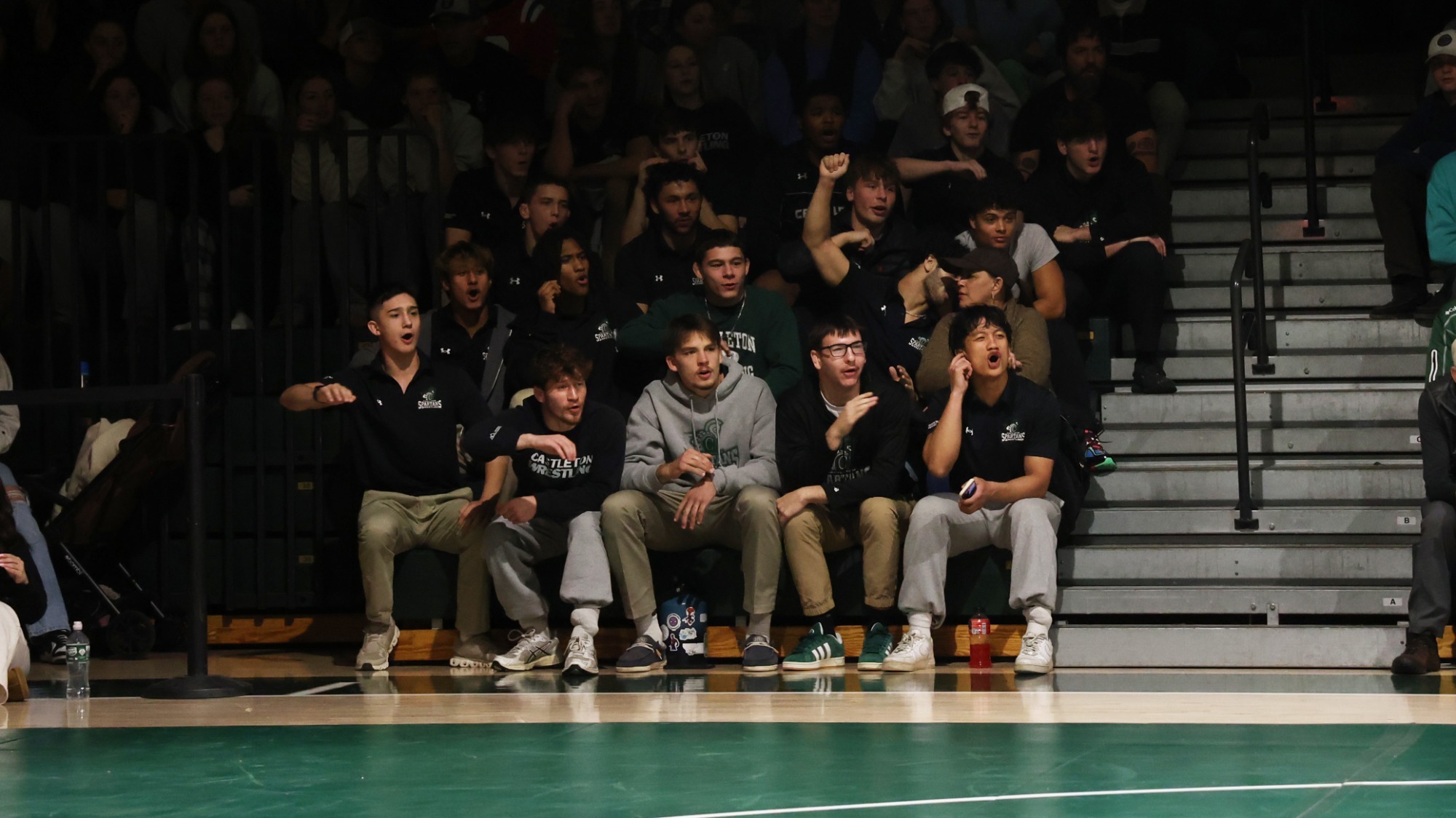 Wrestling Team sitting in bleachers cheering