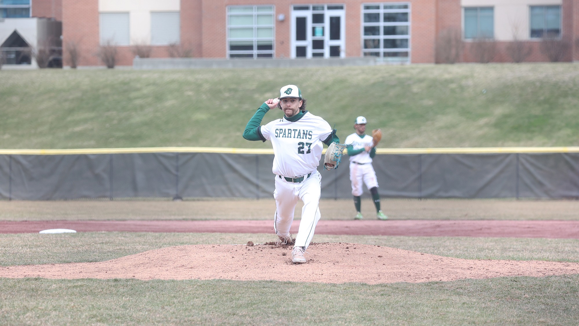 Kevin Hewlett throwing a pitch against Rhode Island College