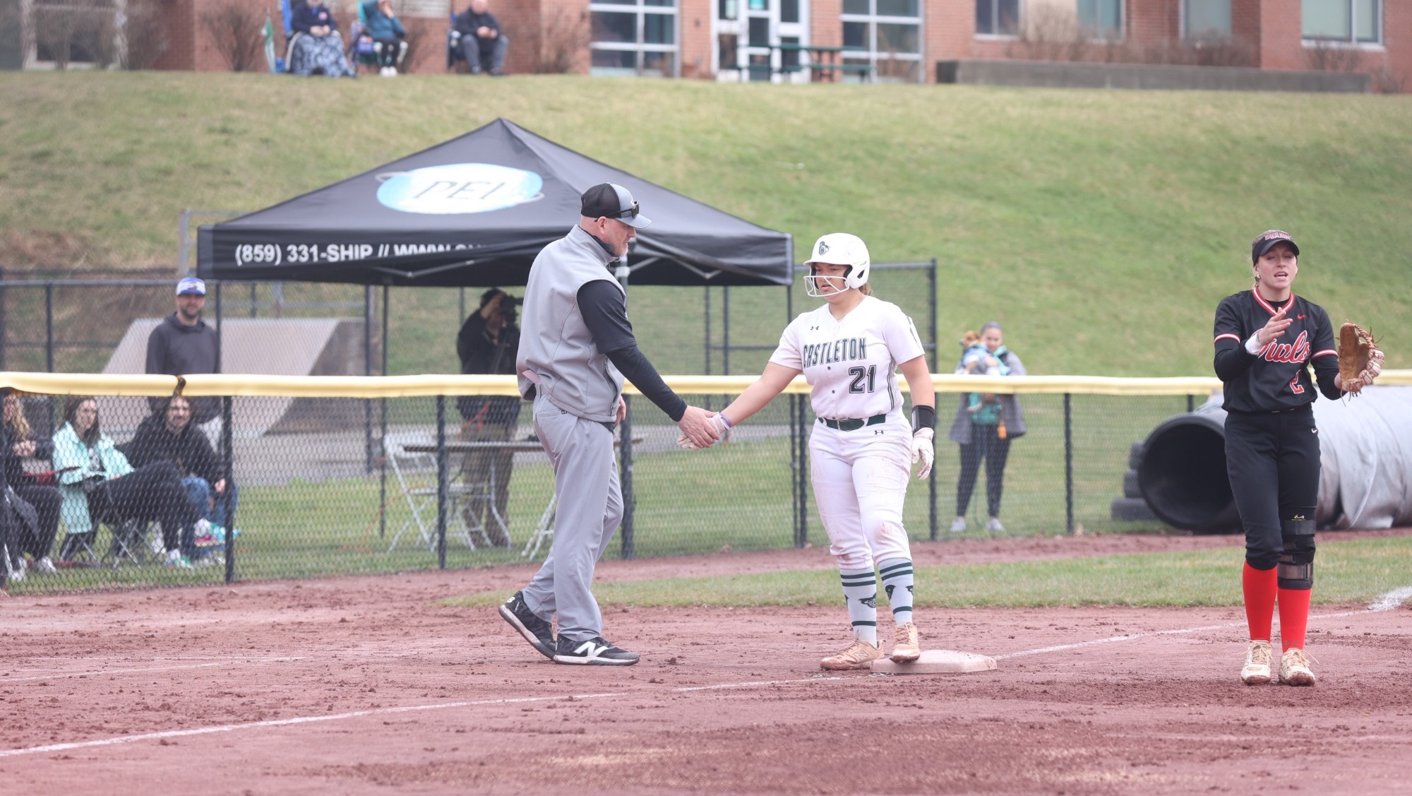 Kraut high-fives Rideout as she stands on third base