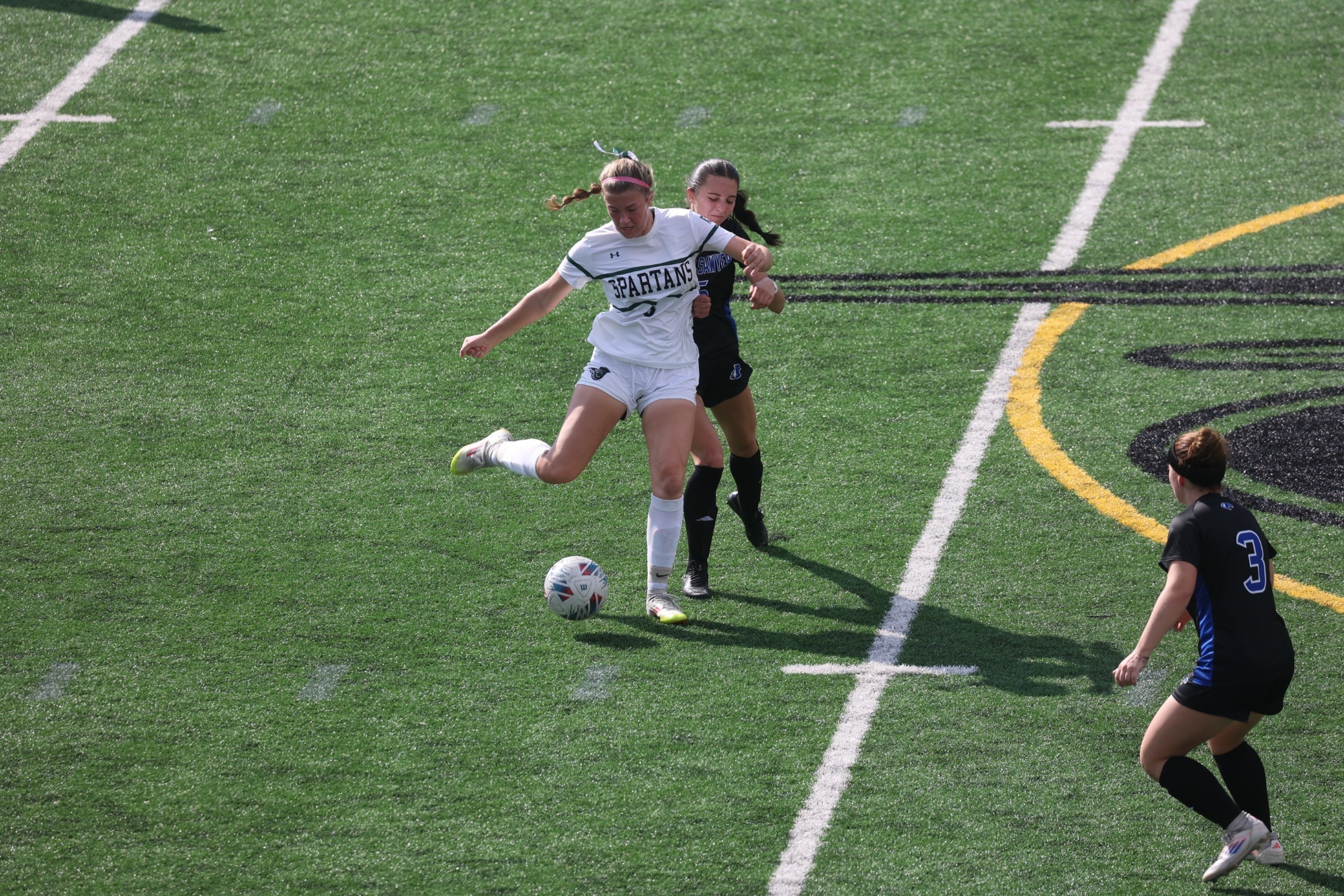Makenna Price playing the ball against defender