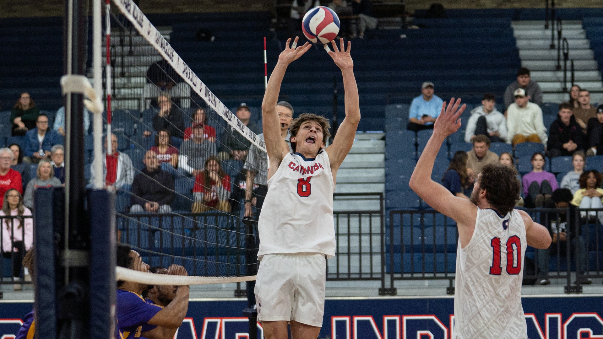 Mason Archer leaping for a set against Benedict