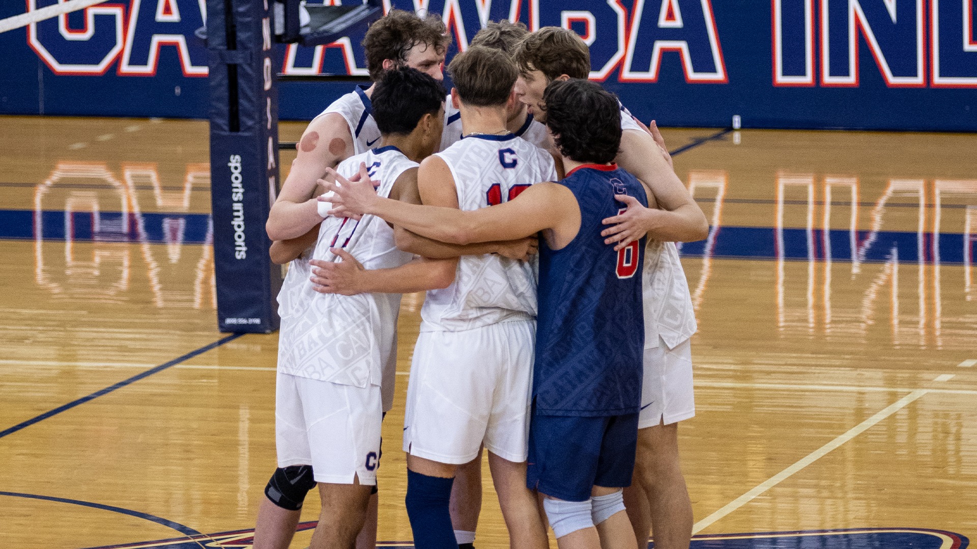 Men's Volleyball huddling against Lees-McRae
