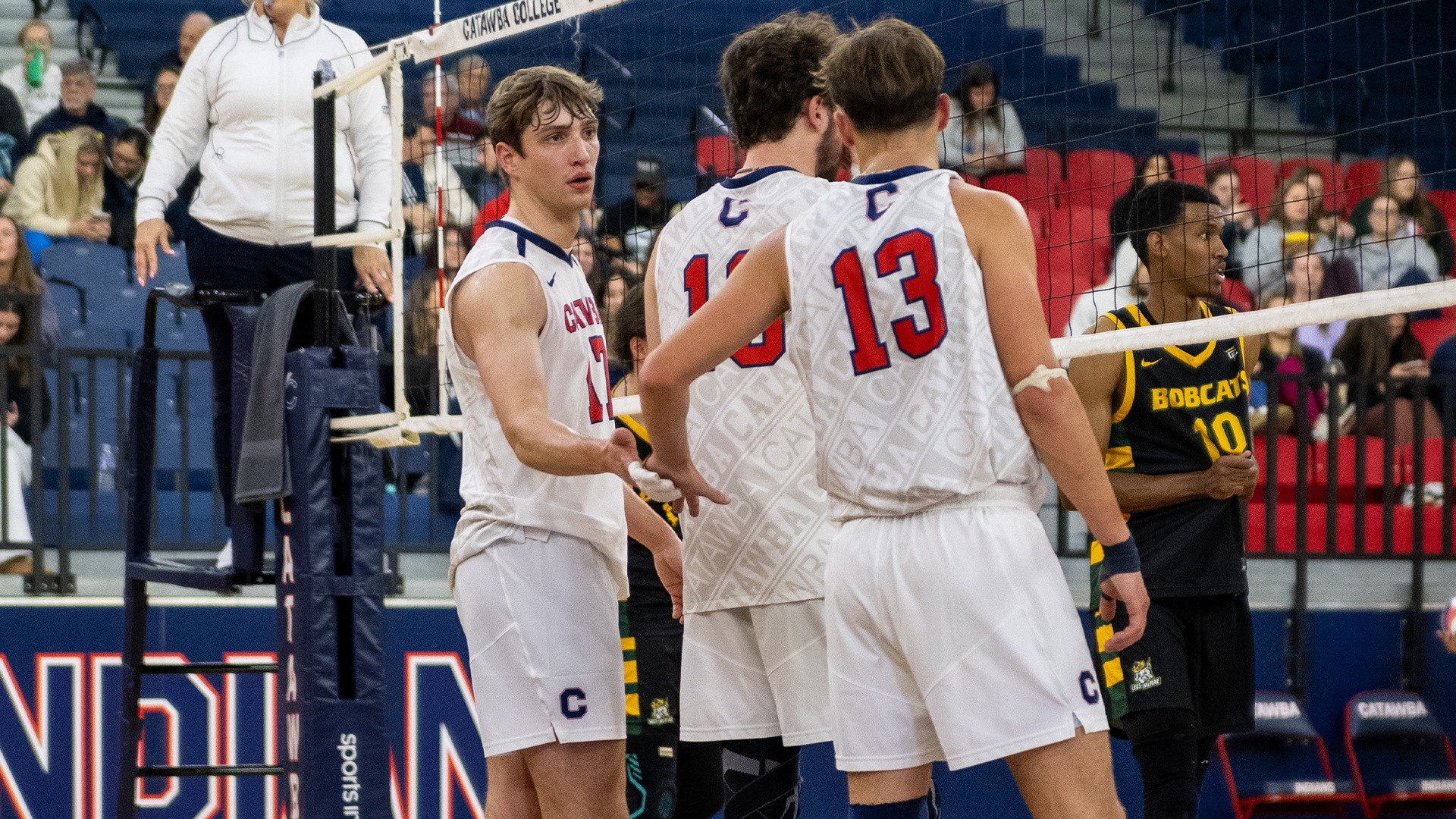 Anders Christianson and teammates talk before a rally against Lees-McRae