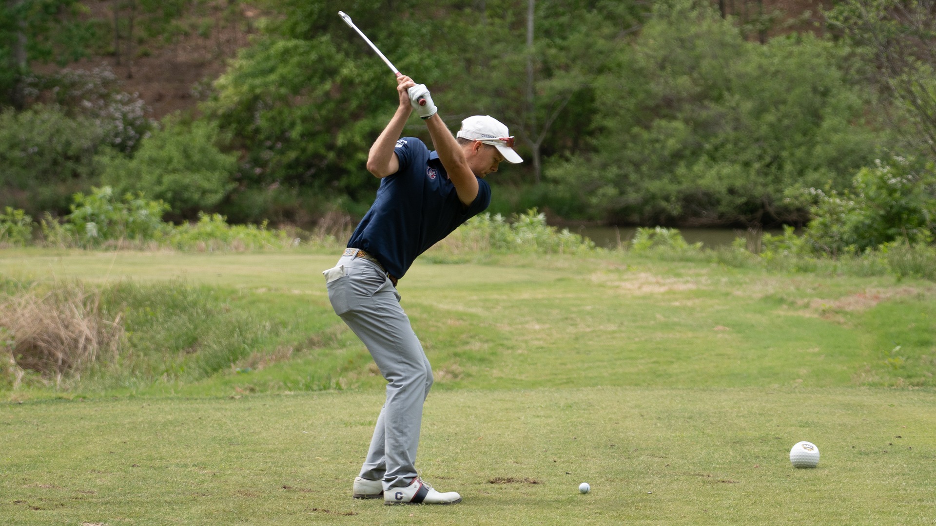 Alec Barker preparing to strike the ball with an iron at the SAC Championship