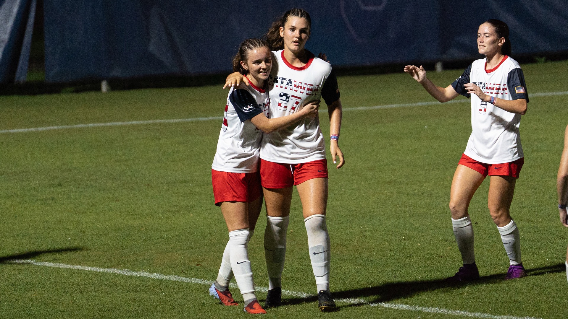Bree Ehmer is hugged by Ella Matthews during Catawba's 9-1 win over Mars Hill