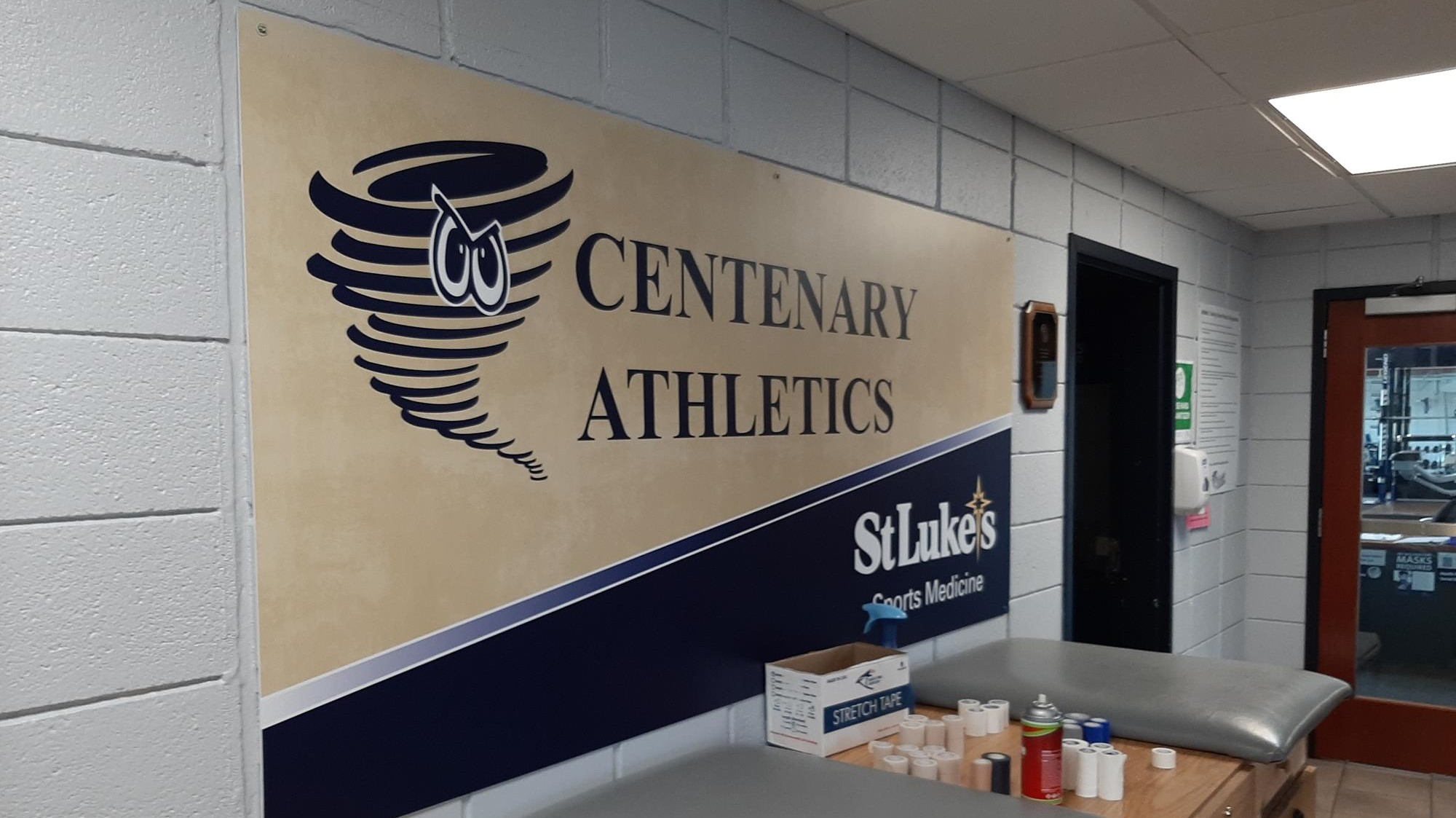 Outside the athletic training room (picture of sign saying athletics and St. Lukes and taping tables)