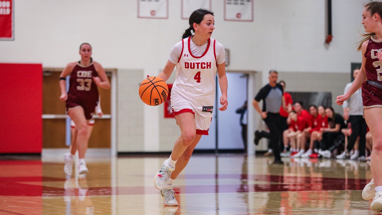 Emily Naughton dribbling up the court against Coe