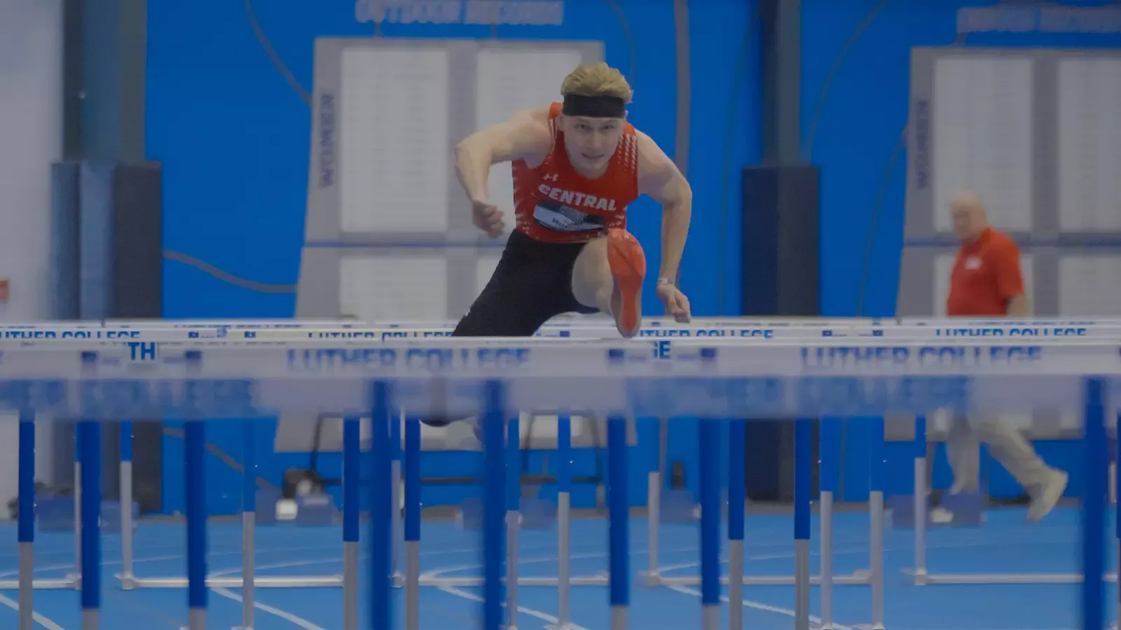 Gage Huyser jumping over hurdle