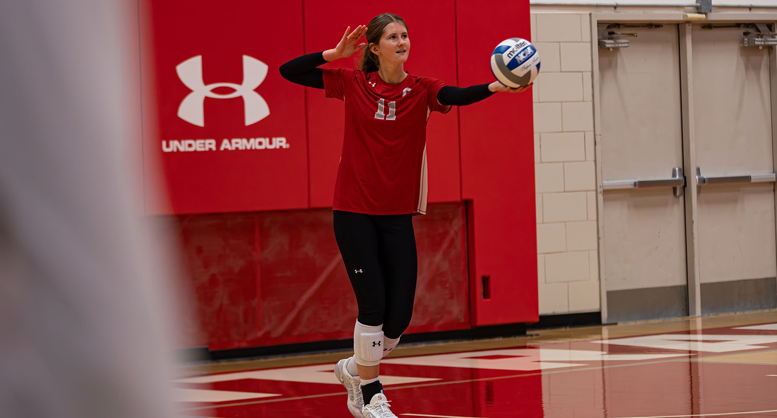Kaitlyn Mumm serves against Luther