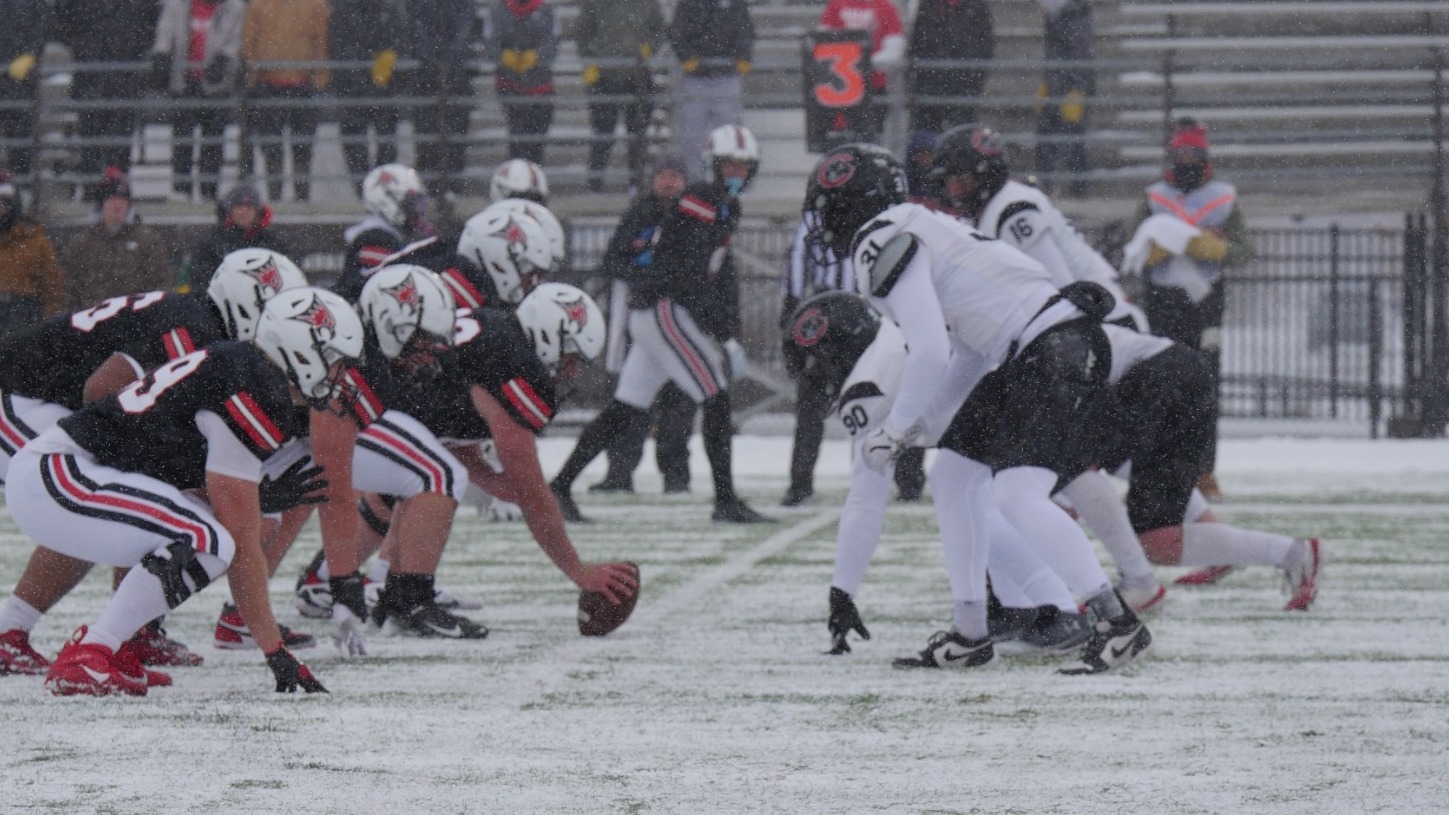 The players line up across the line of scrimmage.